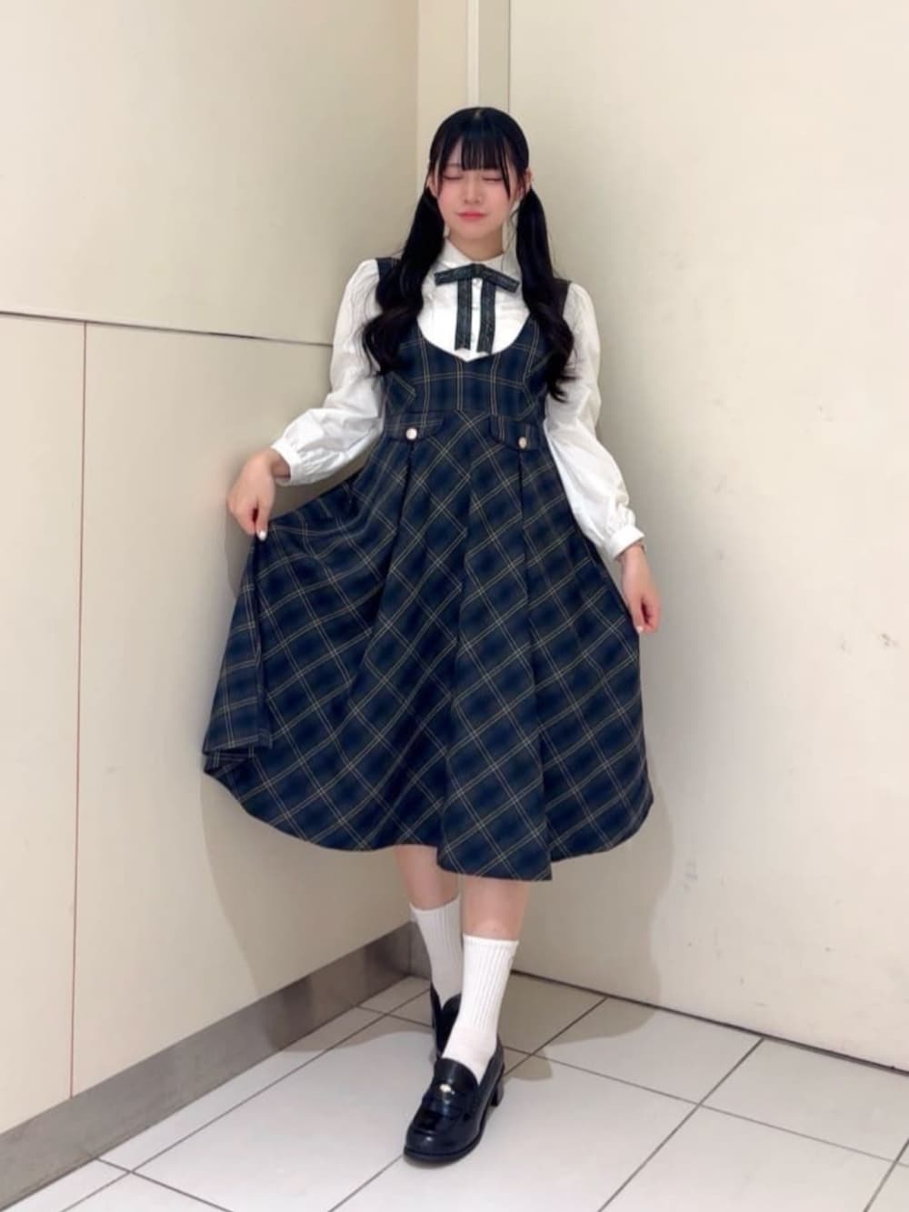 ブラック系のローファー、ブルー系のジャンパースカート、ホワイト系のシャツ/ブラウスを着用したレディースの冬コーディネートの2枚目の写真