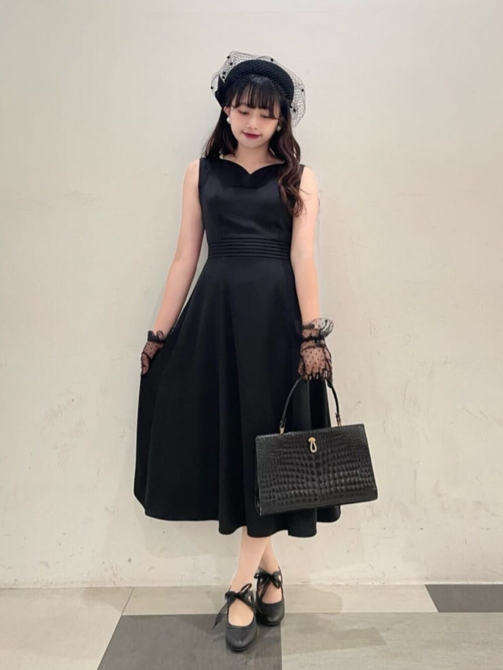 ブラック系のパンプス、ブラック系のドレスを着用したレディースの秋コーディネートの2枚目の写真