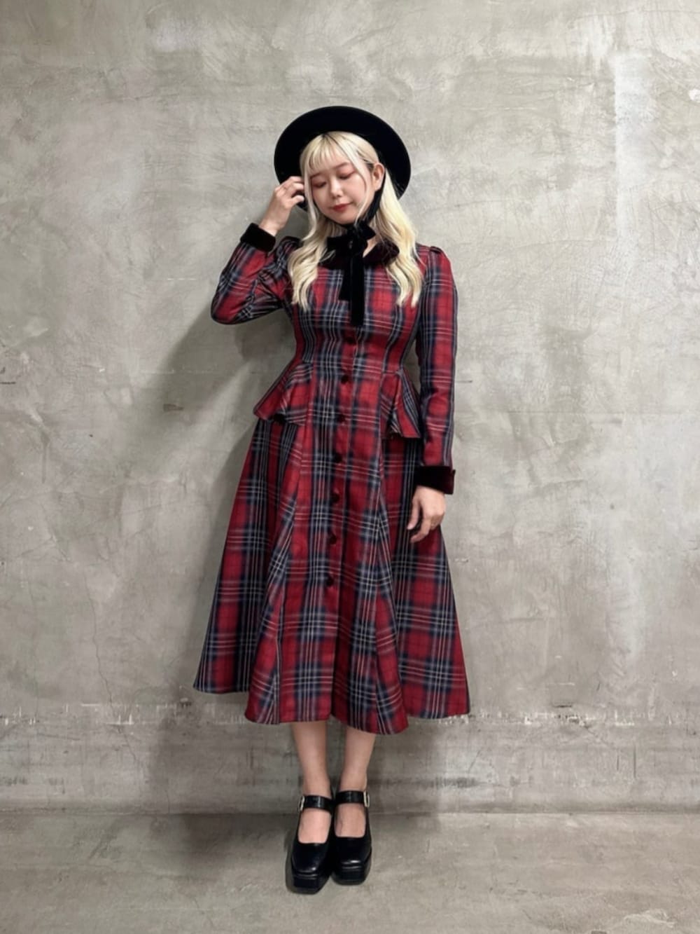 ブラック系のパンプス、レッド系のワンピース、ブラック系のハットを着用したレディースの秋コーディネートの3枚目の写真