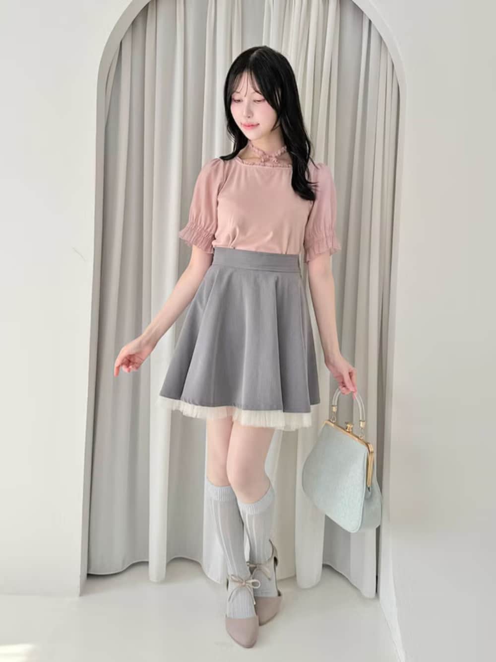 グレー系のスカート、ピンク系のパンプス、ブルー系のハンドバッグを着用したレディースの夏コーディネートの2枚目の写真