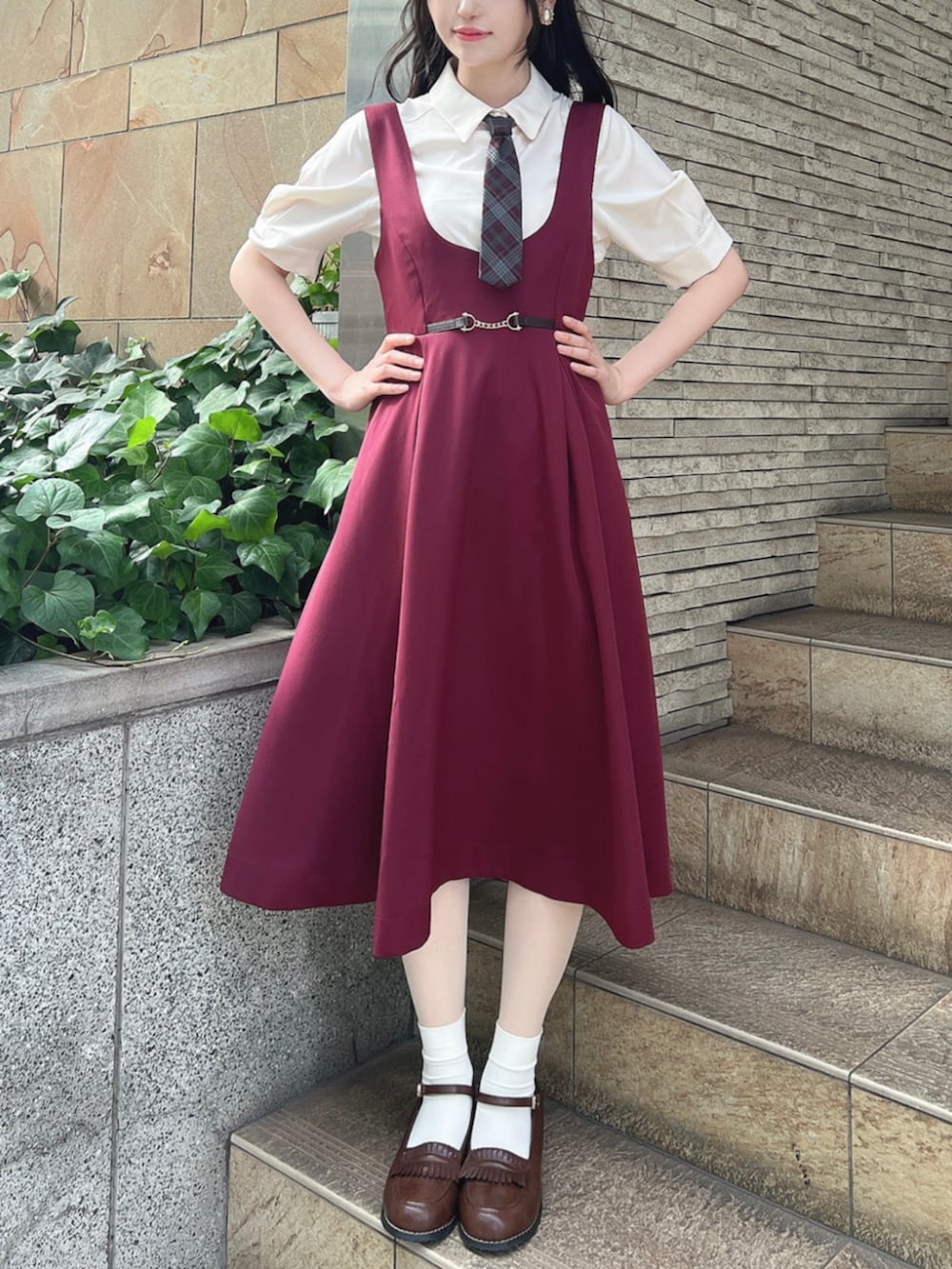 ブラウン系のローファー、レッド系のジャンパースカート、ホワイト系のTシャツ/カットソーを着用したレディースの夏コーディネートの3枚目の写真