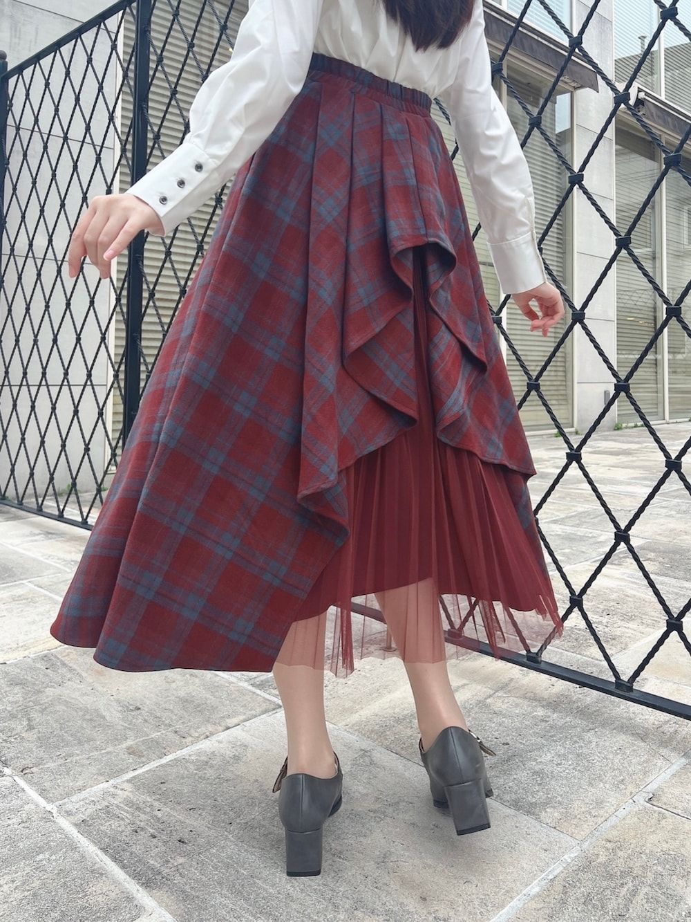 グレー系のパンプス、レッド系のスカート、ホワイト系のシャツ/ブラウスを着用したレディースの秋コーディネートの3枚目の写真