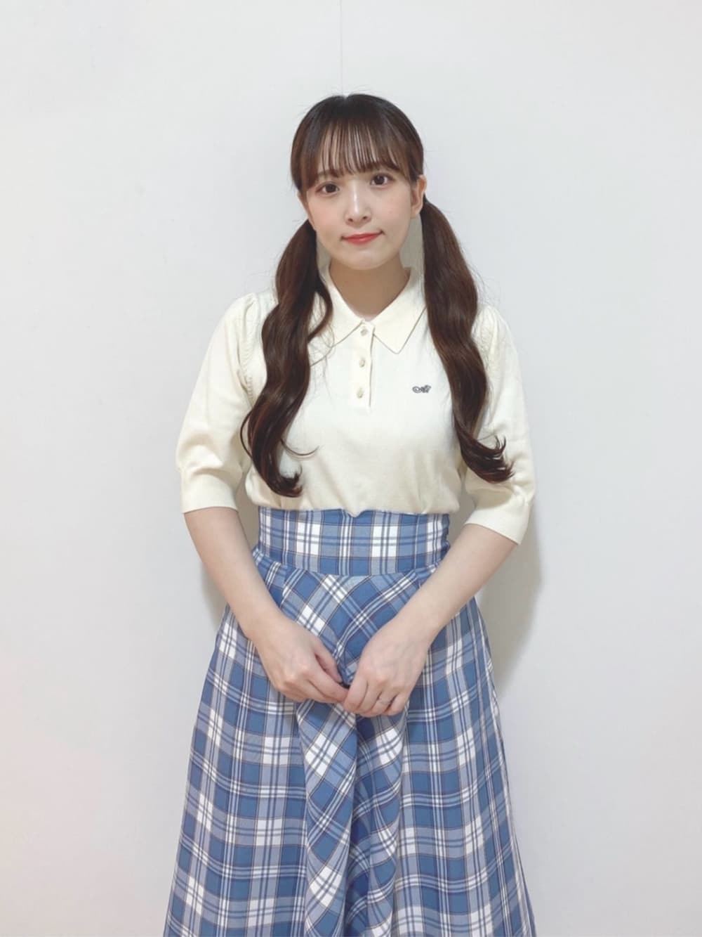 ホワイト系のポロシャツ、ブルー系のスカート、ホワイト系のサンダルを着用したレディースの夏コーディネートの2枚目の写真