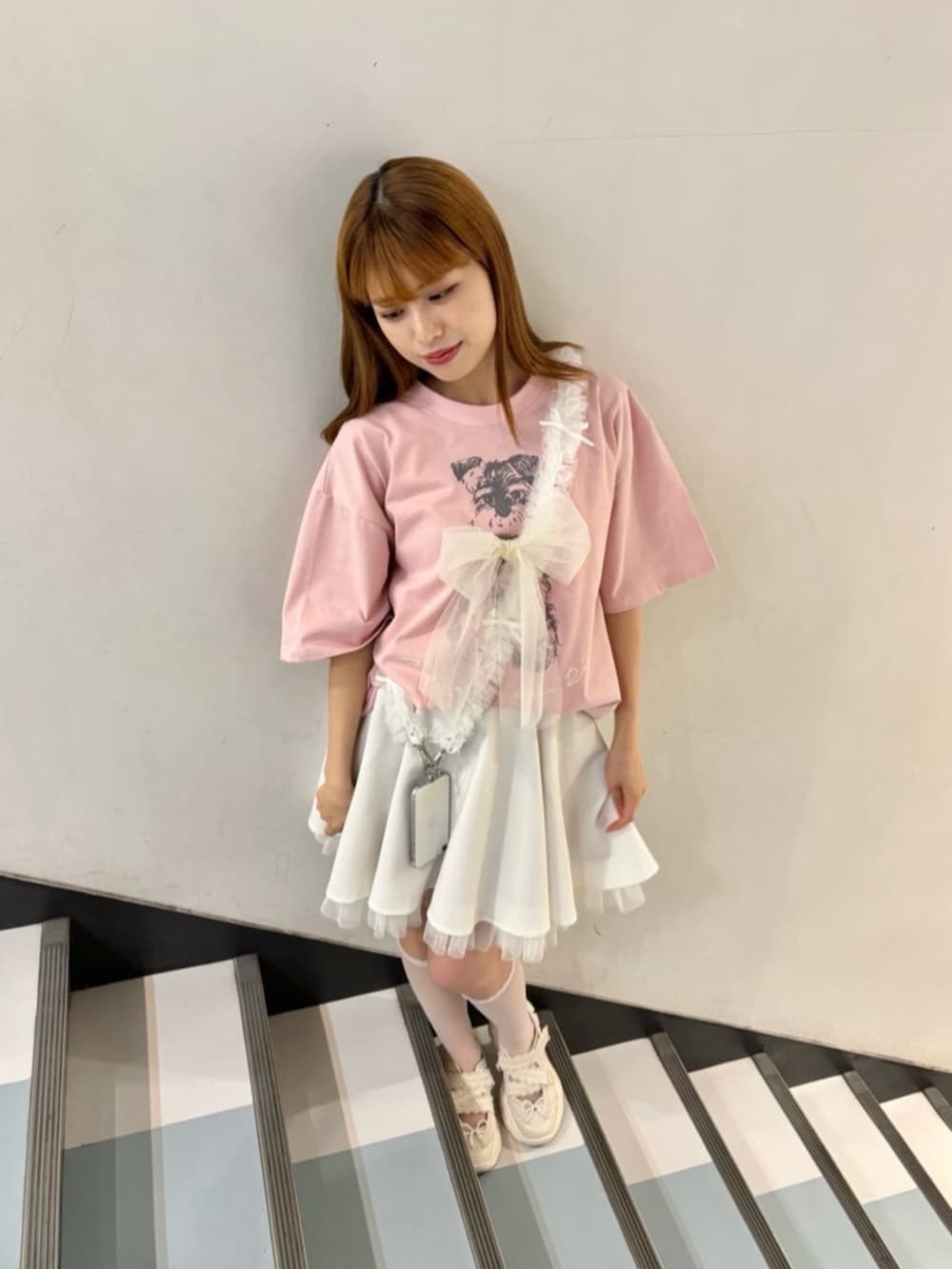 ホワイト系のスカート、ホワイト系のスニーカー、ピンク系のTシャツ/カットソーを着用したレディースの春コーディネートの2枚目の写真