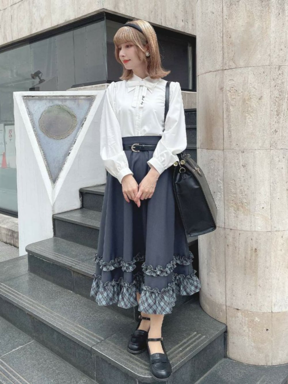 ブラック系のローファー、ブルー系のスカート、ホワイト系のシャツ/ブラウスを着用したレディースの秋コーディネートの2枚目の写真