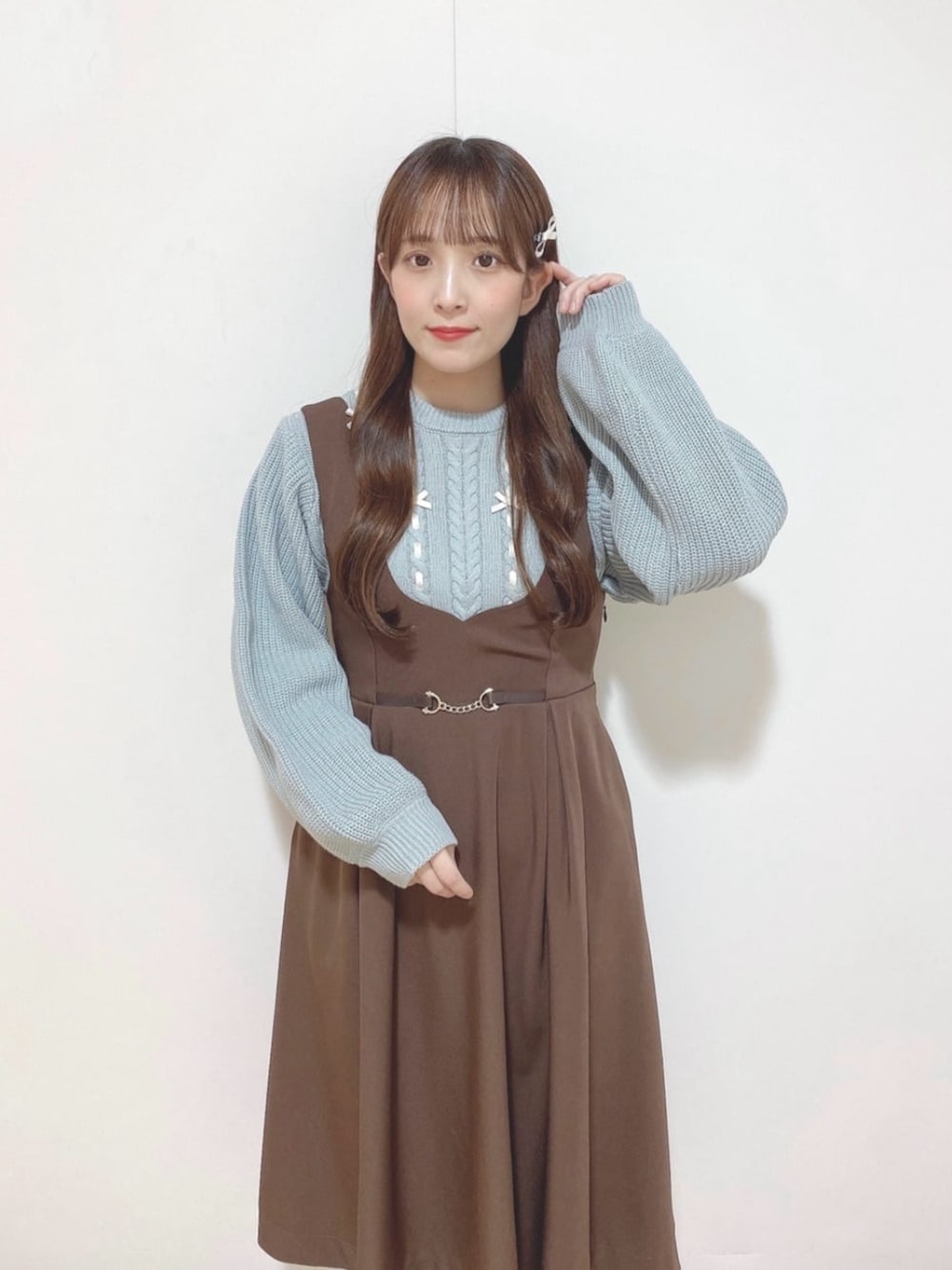 ブラウン系のジャンパースカート、ブラウン系のバレエシューズ、グリーン系のショルダーバッグを着用したレディースの冬コーディネートの3枚目の写真