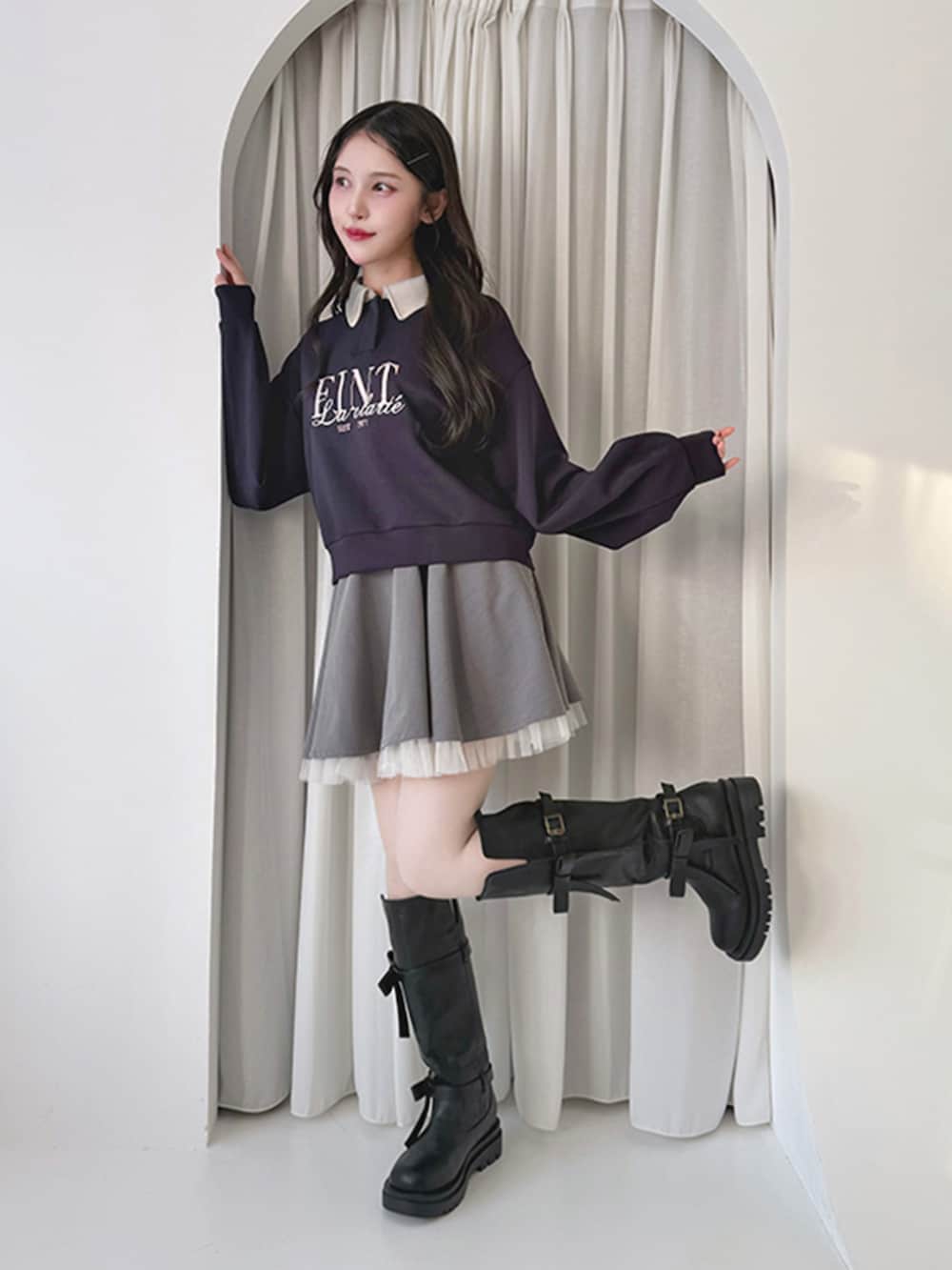 グレー系のスカート、ブラック系のブーツ、ブルー系のスウェットを着用したレディースの冬コーディネートの2枚目の写真