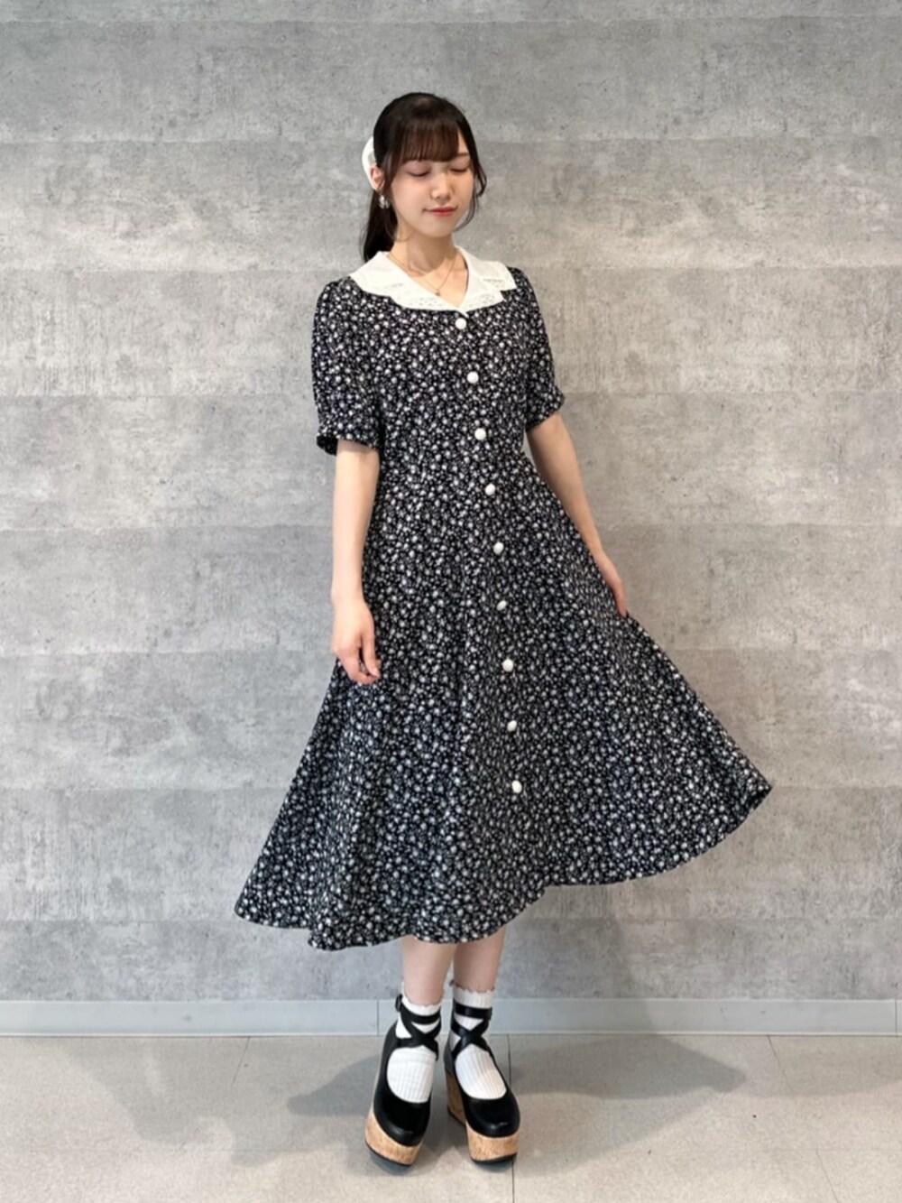 ベージュ系のハンドバッグ、ブラック系のワンピースを着用したレディースの春コーディネートの2枚目の写真