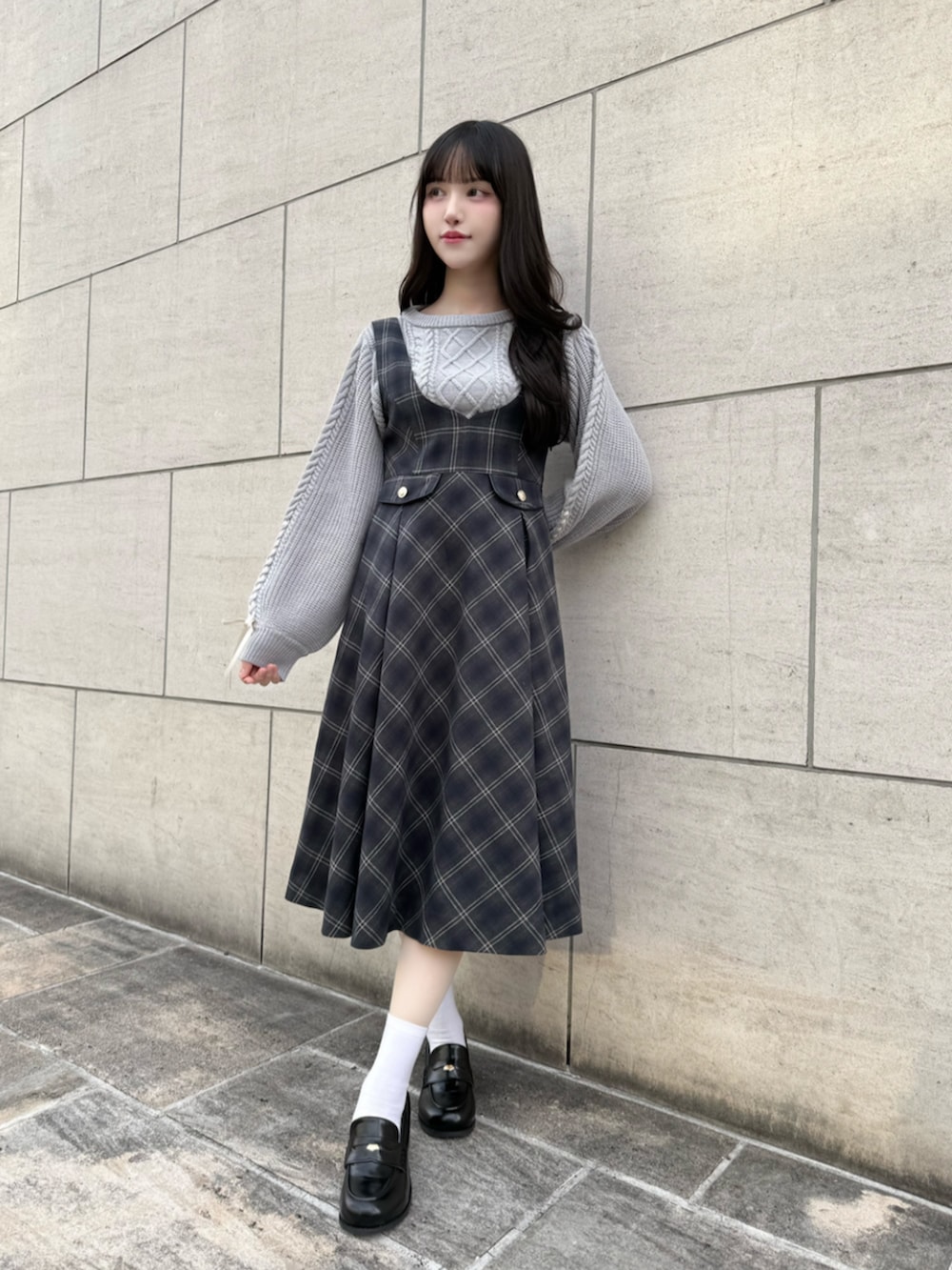 ブラック系のローファー、グレー系のニット/セーター、ブルー系のジャンパースカートを着用したレディースの冬コーディネートの3枚目の写真