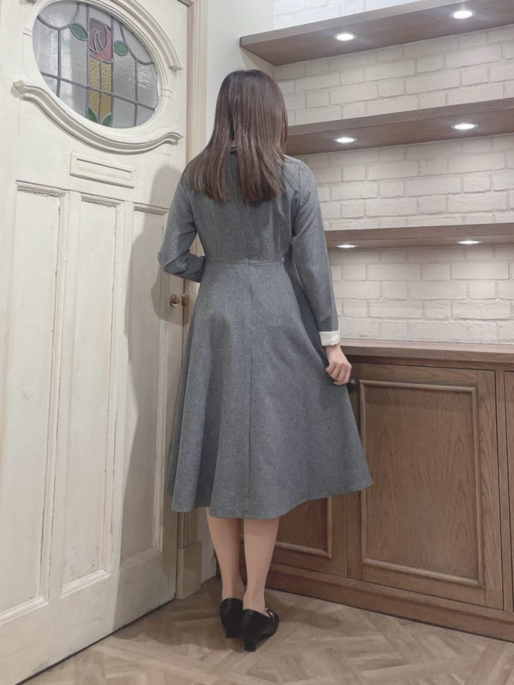 ブラック系のパンプス、グレー系のワンピースを着用したレディースの冬コーディネートの2枚目の写真