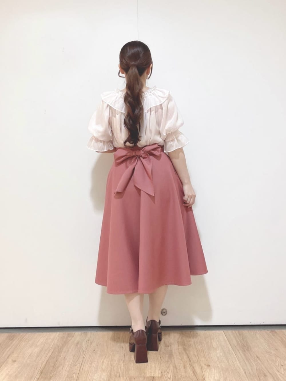 ピンク系のスカート、ブラウン系のパンプス、ピンク系のシャツ/ブラウスを着用したレディースの夏コーディネートの4枚目の写真