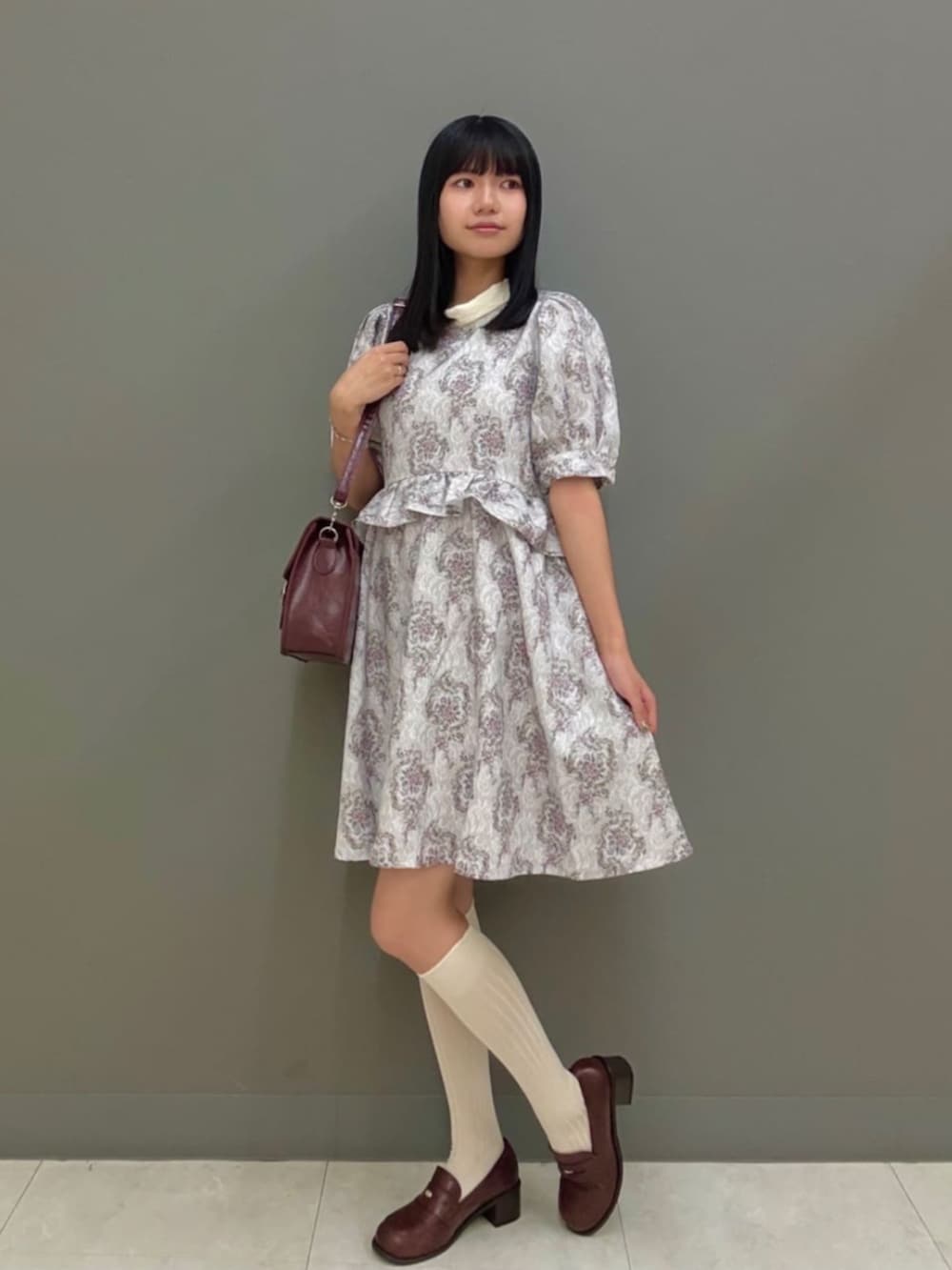 ブラウン系のローファー、ブラウン系のショルダーバッグ、ピンク系のワンピースを着用したレディースの夏コーディネートの2枚目の写真