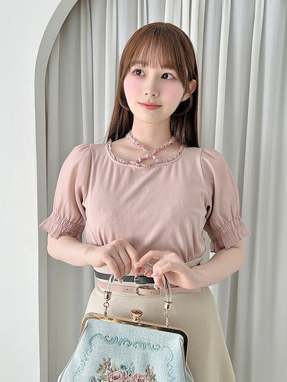 ベージュ系のスカート、ピンク系のパンプス、ブルー系のハンドバッグを着用したレディースの夏コーディネートの2枚目の写真