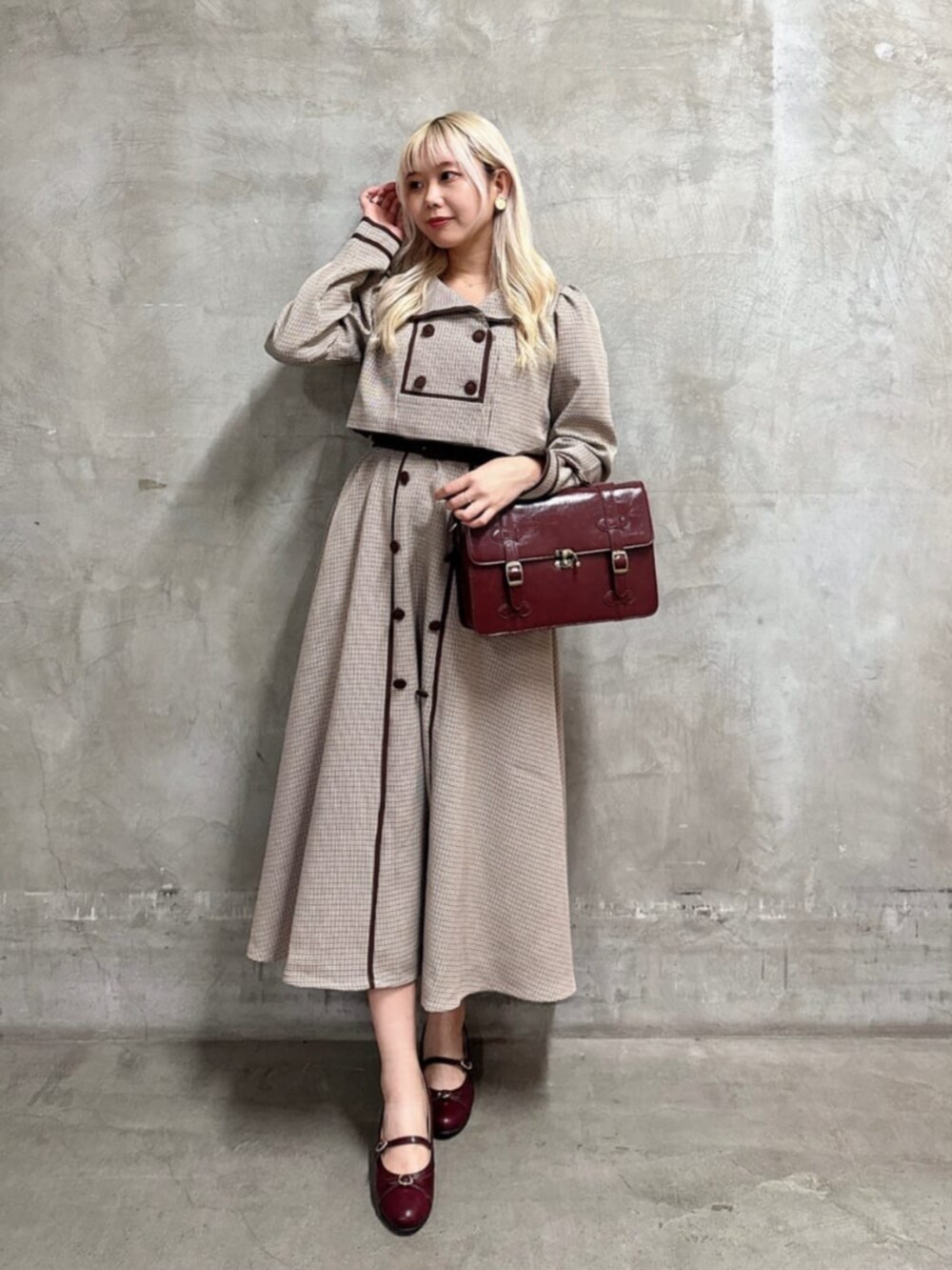 ブラウン系のショルダーバッグ、レッド系のパンプス、ベージュ系のセットアップを着用したレディースの秋コーディネートの4枚目の写真