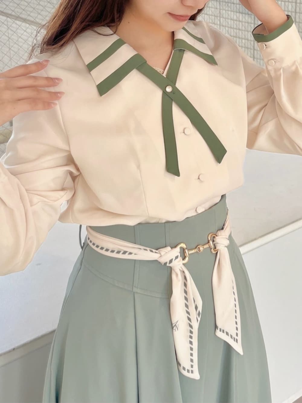 ホワイト系のハンドバッグ、ホワイト系のシャツ/ブラウス、グリーン系のスカートを着用したレディースの冬コーディネートの3枚目の写真