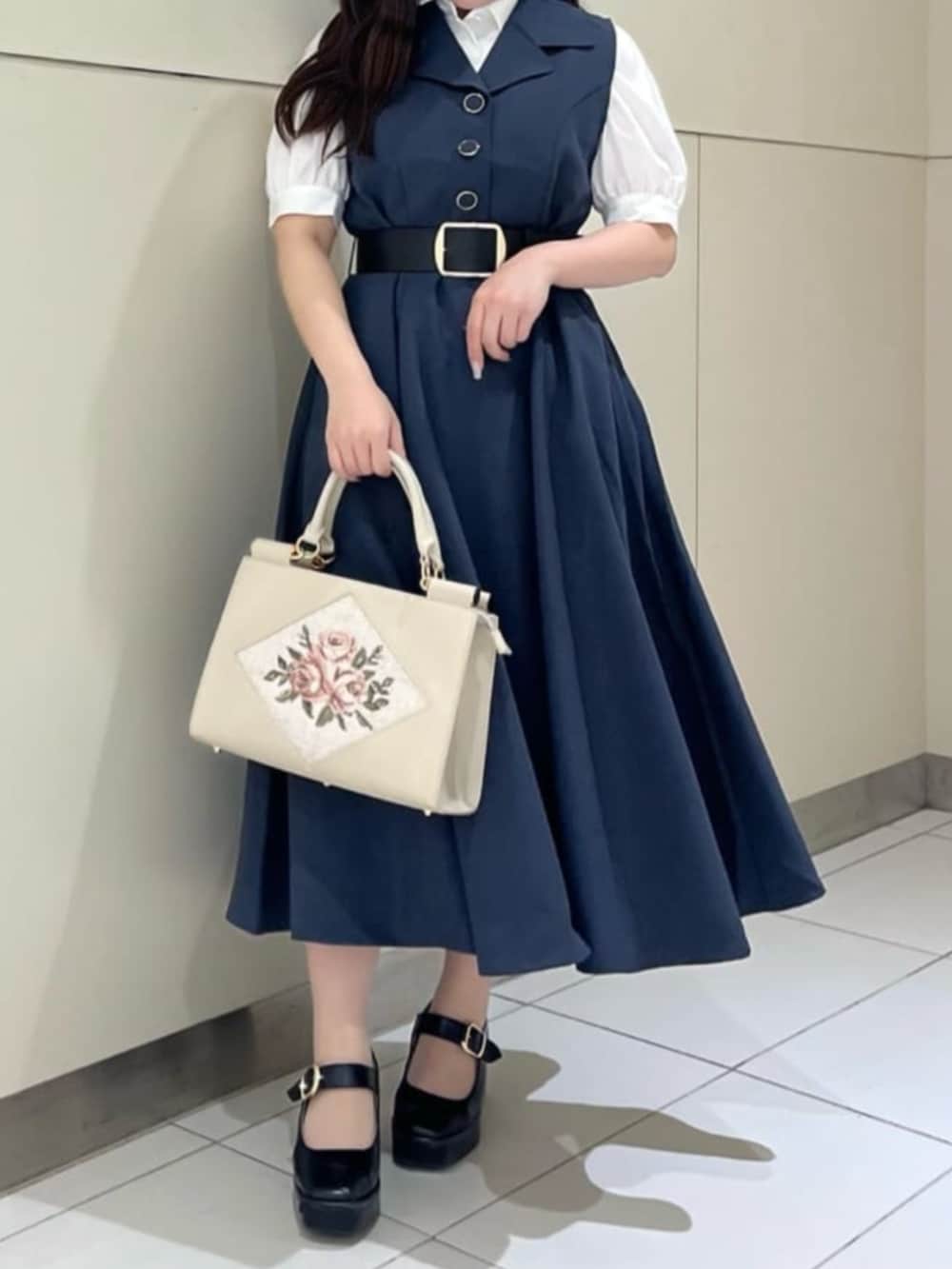 ブラック系のパンプス、ホワイト系のトートバッグ、ホワイト系のシャツ/ブラウスを着用したレディースの夏コーディネートの2枚目の写真