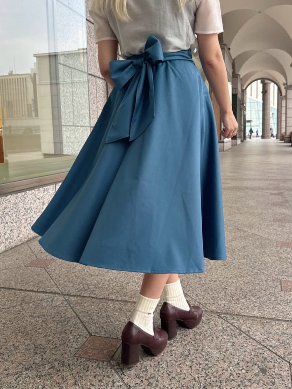 ホワイト系のシャツ/ブラウス、ブルー系のスカートを着用したレディースの春コーディネートの3枚目の写真