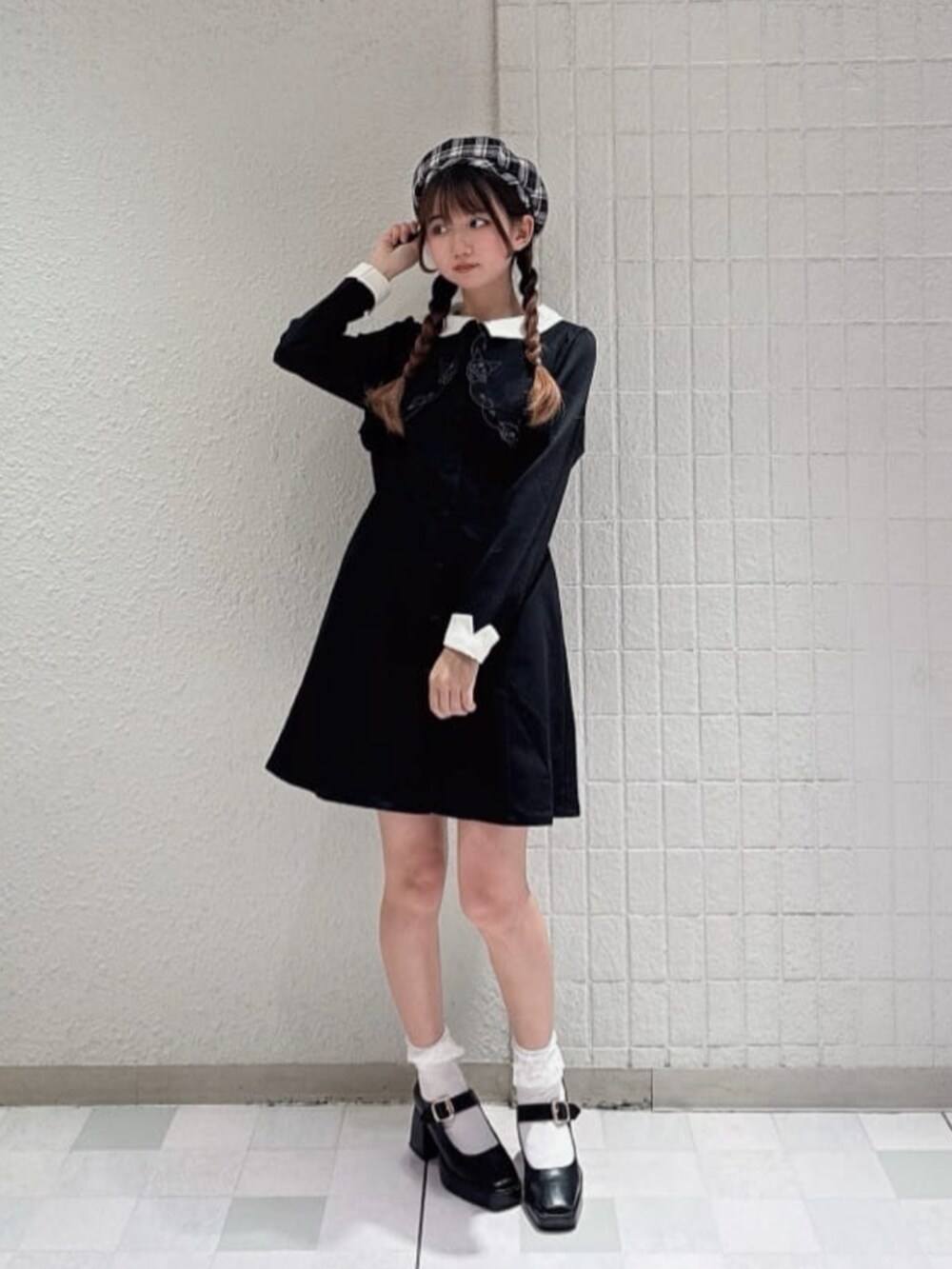 ブラック系のパンプス、ブラック系のワンピース、ホワイト系のハンチング/ベレー帽を着用したレディースの冬コーディネートの2枚目の写真