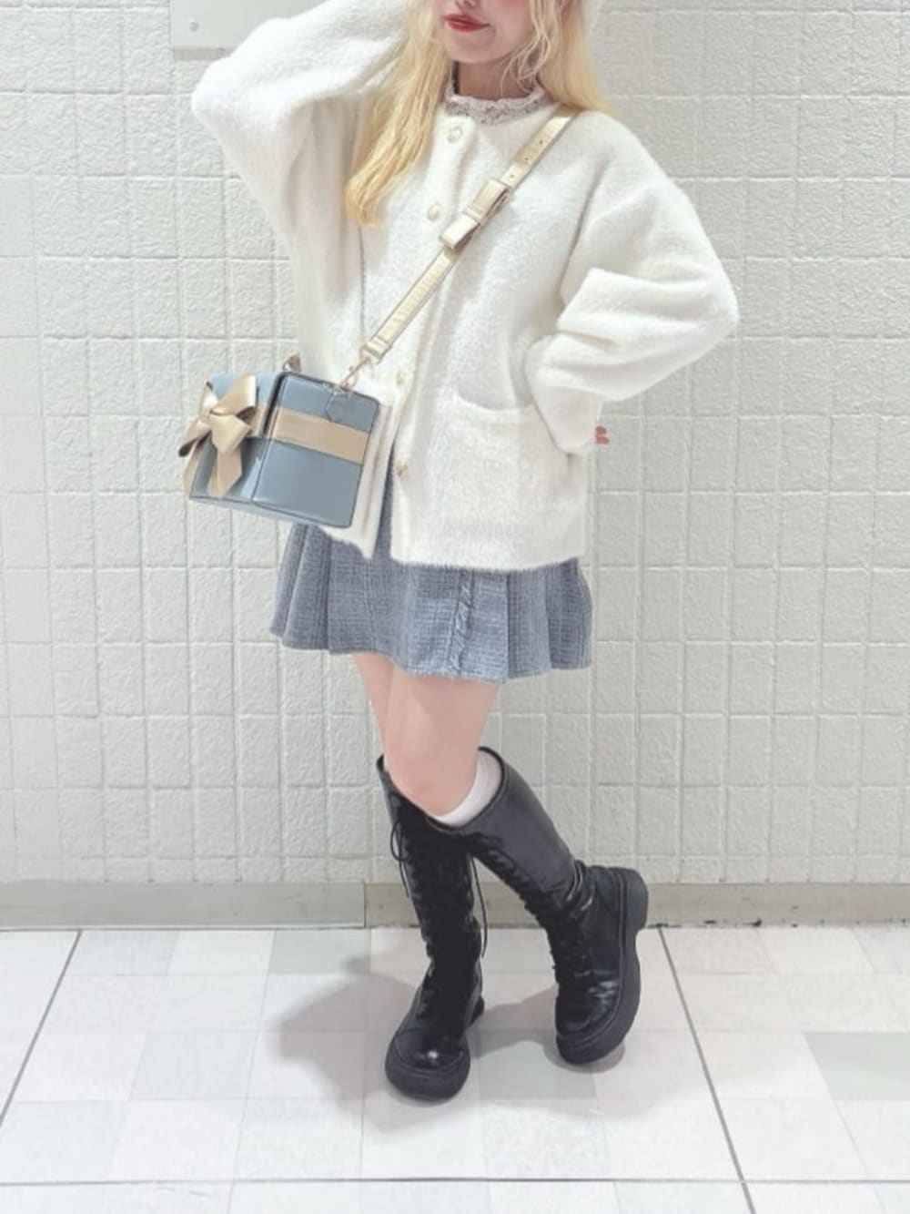 ホワイト系のTシャツ/カットソー、ホワイト系のカーディガン/ボレロ、ブルー系のショルダーバッグを着用したレディースの冬コーディネートの3枚目の写真