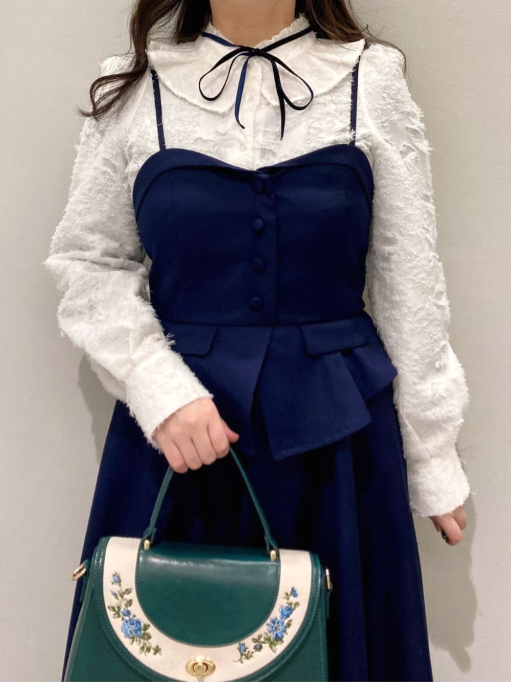 ブルー系のハンドバッグ、ブルー系のパンプス、ホワイト系のシャツ/ブラウスを着用したレディースの冬コーディネートの4枚目の写真