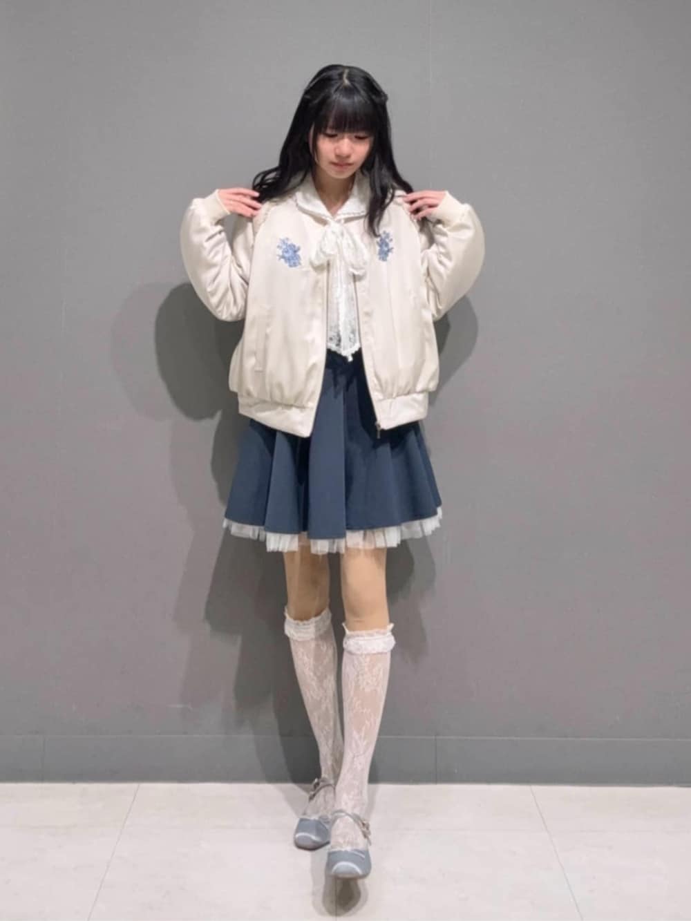 ブルー系のスカート、ホワイト系のシャツ/ブラウス、ホワイト系のブルゾンを着用したレディースの冬コーディネートの2枚目の写真
