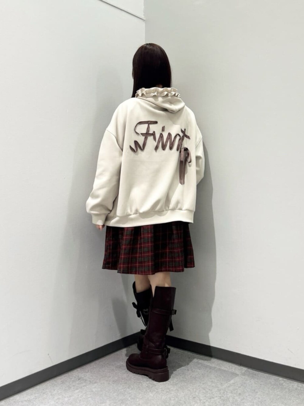 ブラウン系のブーツ、レッド系のワンピース、ベージュ系のパーカーを着用したレディースの秋コーディネートの3枚目の写真