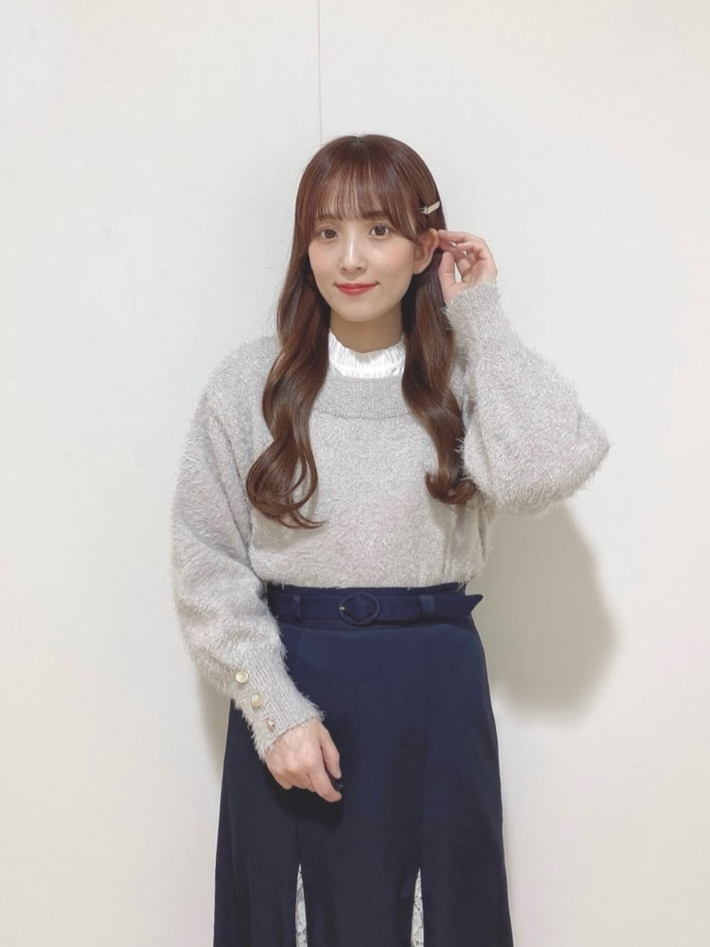 ブラック系のパンプス、ホワイト系のシャツ/ブラウス、グレー系のニット/セーターを着用したレディースの冬コーディネートの2枚目の写真