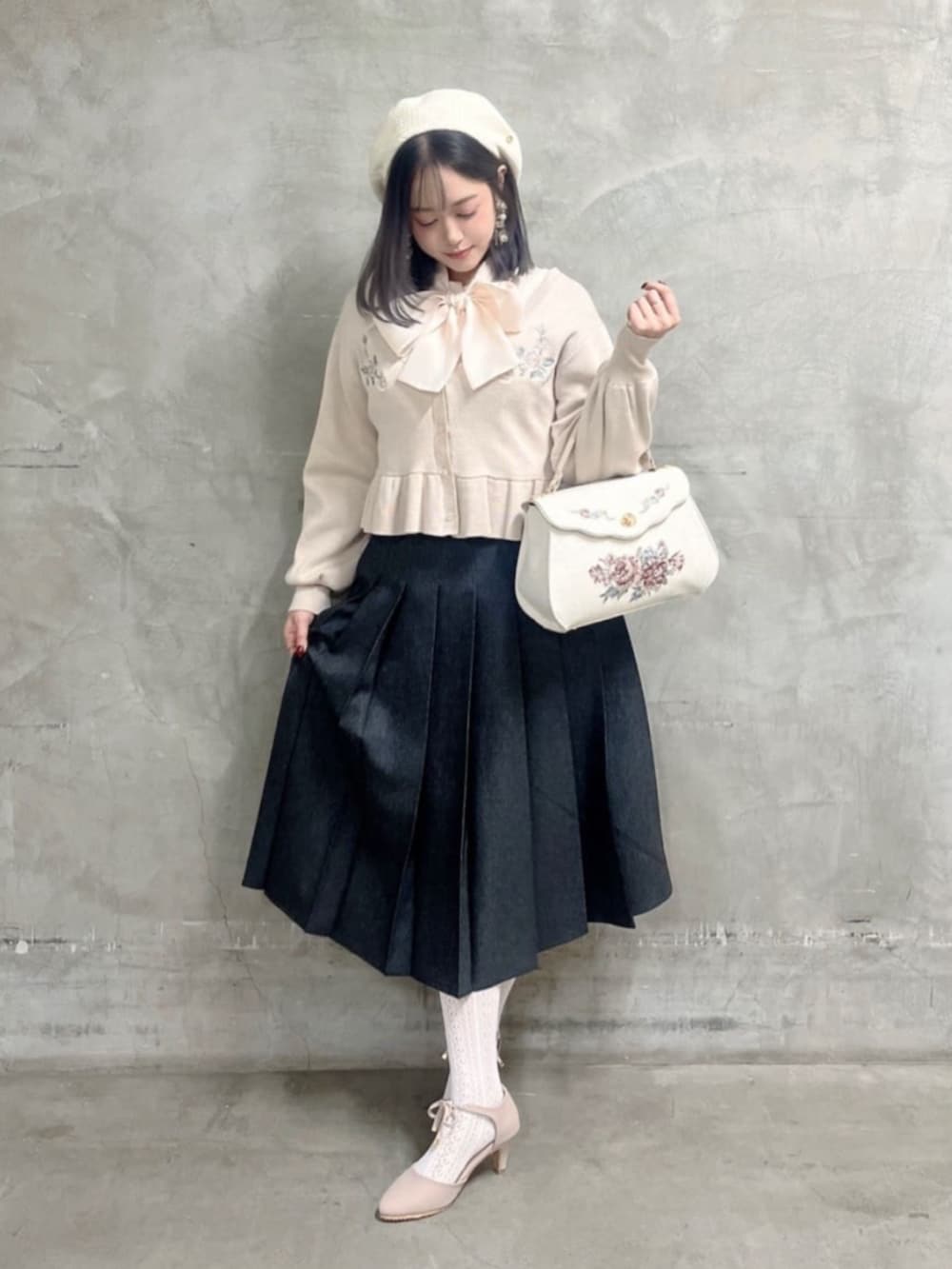 ブラック系のデニムスカート、ピンク系のシャツ/ブラウス、ホワイト系のハンドバッグを着用したレディースの冬コーディネートの2枚目の写真