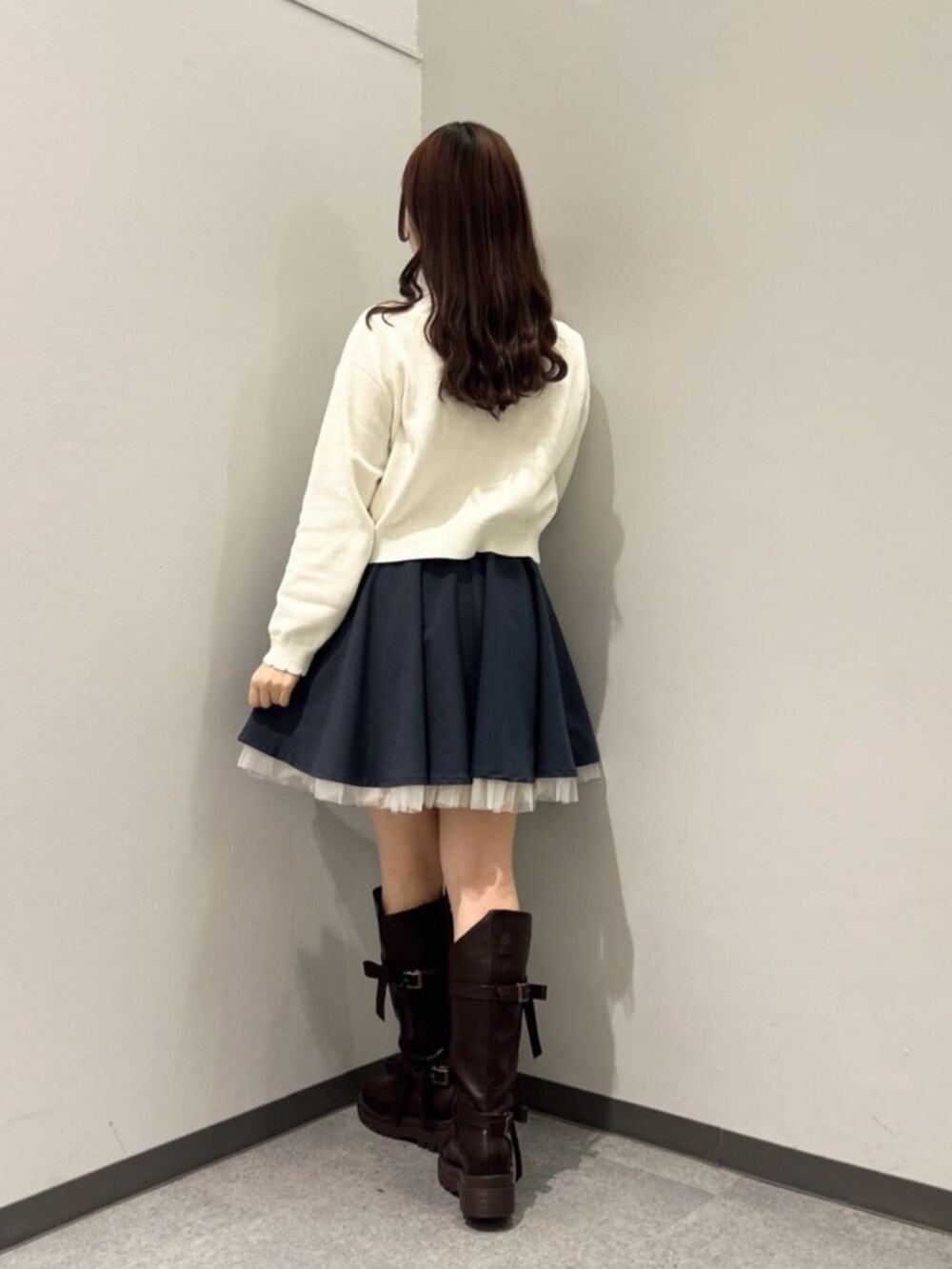 ブラウン系のブーツ、ホワイト系のニット/セーター、ブルー系のスカートを着用したレディースの冬コーディネートの4枚目の写真
