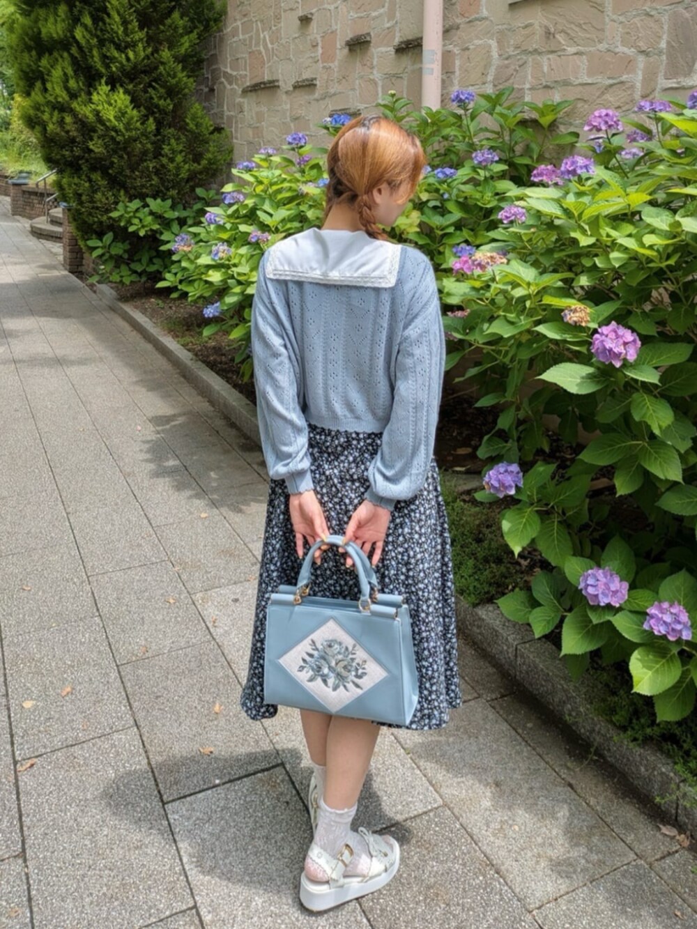 ブラック系のワンピース、ホワイト系のサンダル、ブルー系のトートバッグを着用したレディースの夏コーディネートの3枚目の写真