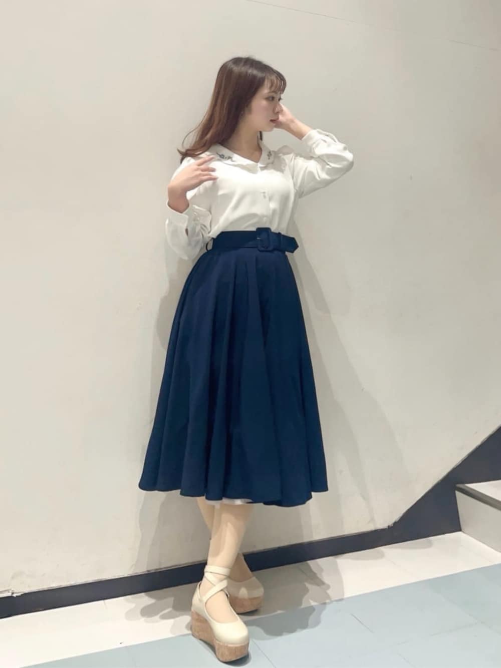 ホワイト系のパンプス、ブルー系のスカート、ホワイト系のシャツ/ブラウスを着用したレディースの冬コーディネートの2枚目の写真