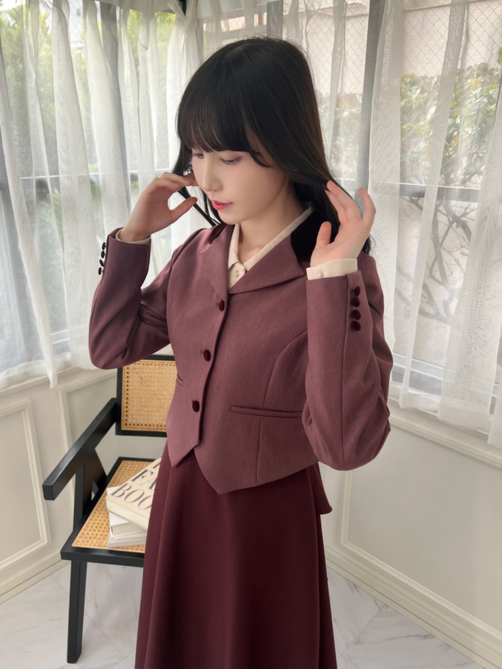 レッド系のパンプス、レッド系のテーラードジャケット、レッド系のスカートを着用したレディースの秋コーディネートの3枚目の写真