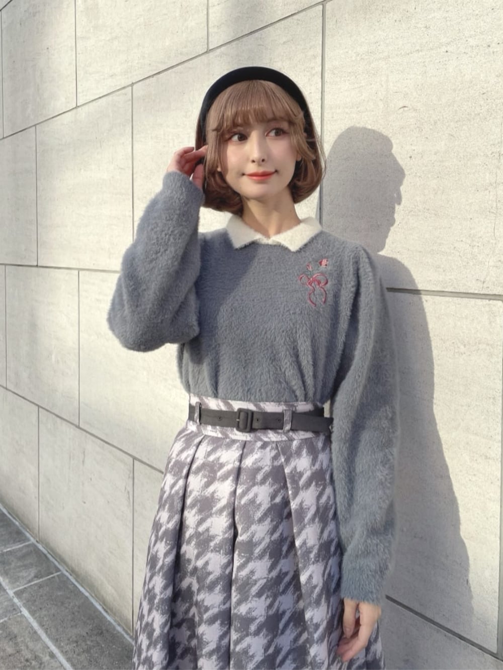 グレー系のスカート、グレー系のパンプス、グレー系のニット/セーターを着用したレディースの冬コーディネートの2枚目の写真