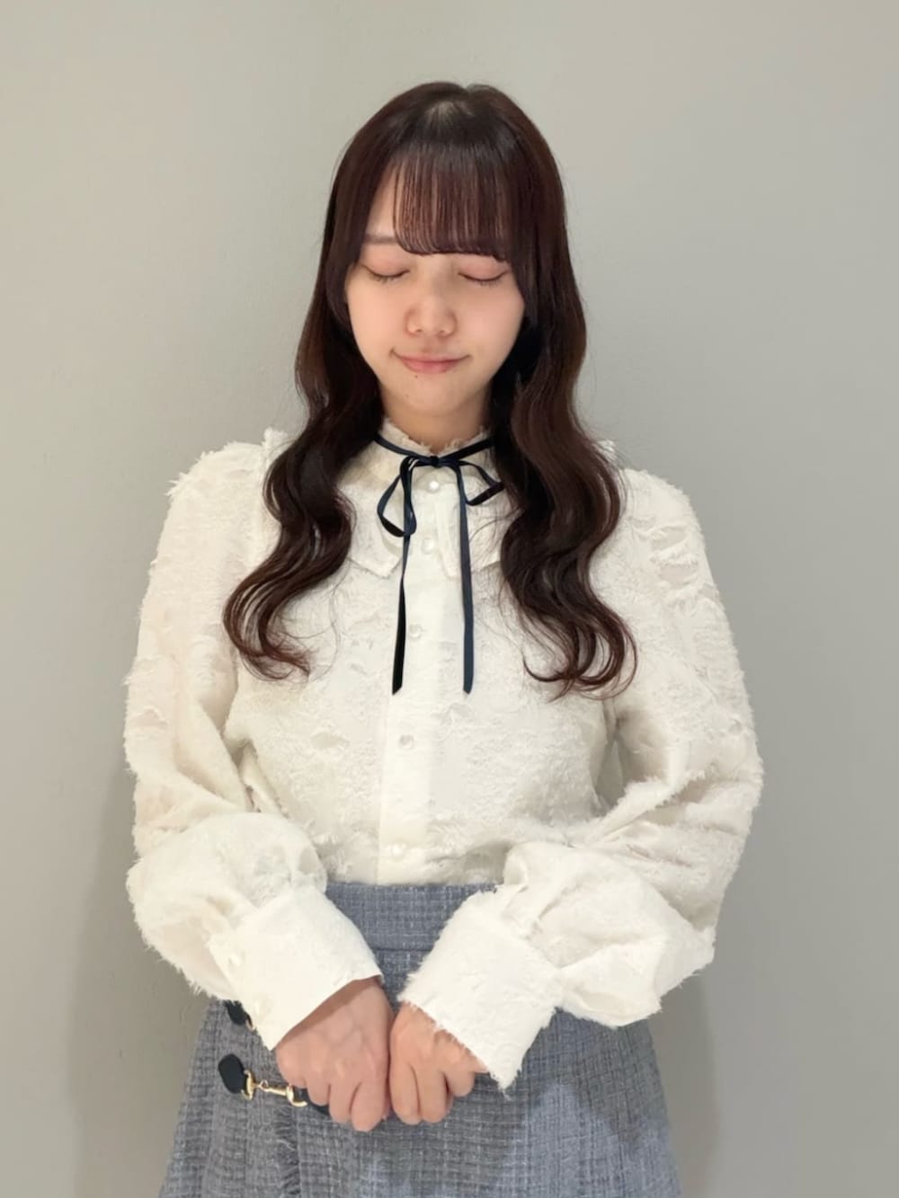 ホワイト系のダウンジャケット/コート、ブラック系のブーツ、ホワイト系のシャツ/ブラウスを着用したレディースの秋コーディネートの2枚目の写真