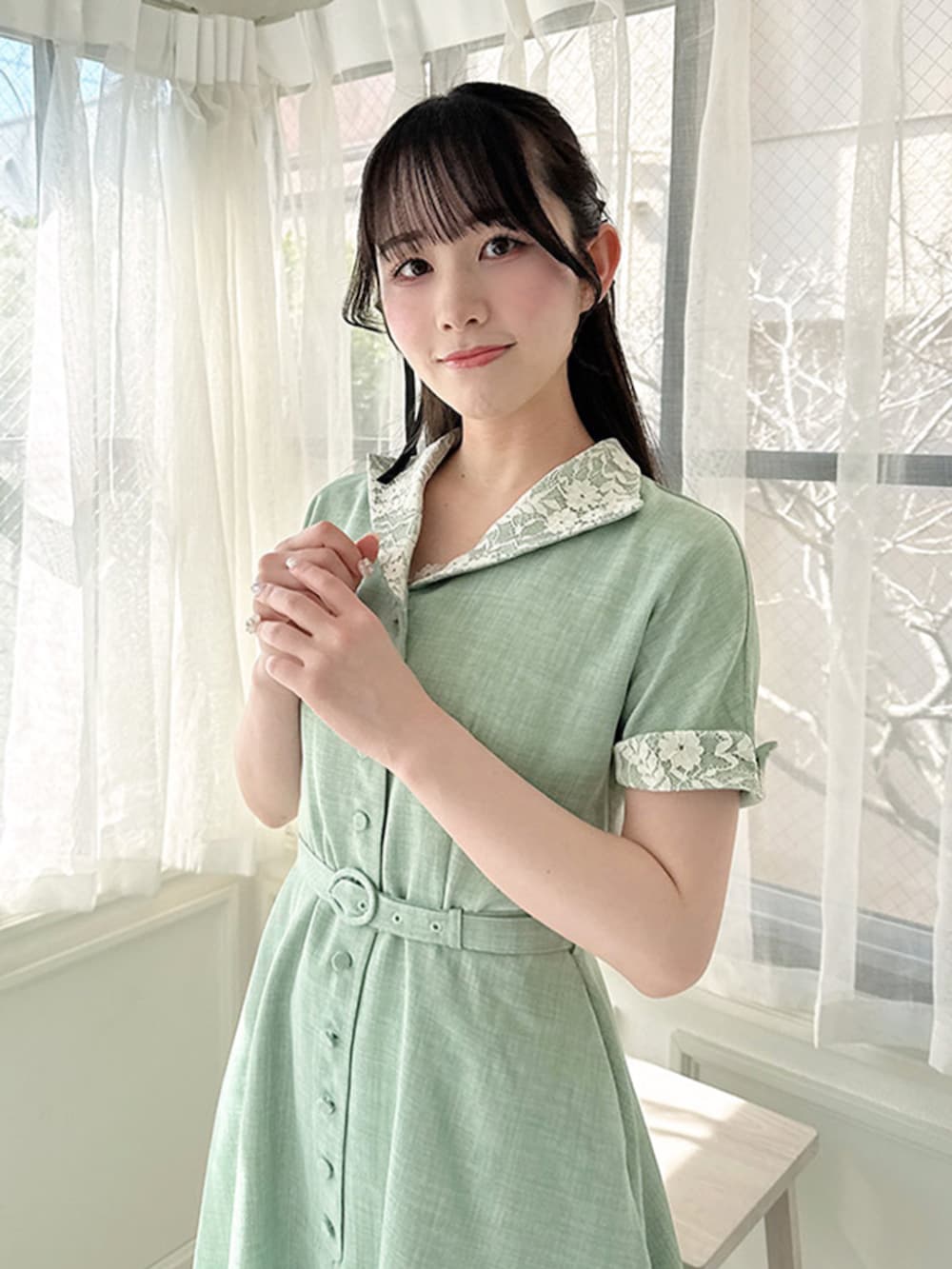 ホワイト系のパンプス、グリーン系のワンピース、ホワイト系のカーディガン/ボレロを着用したレディースの春コーディネートの3枚目の写真