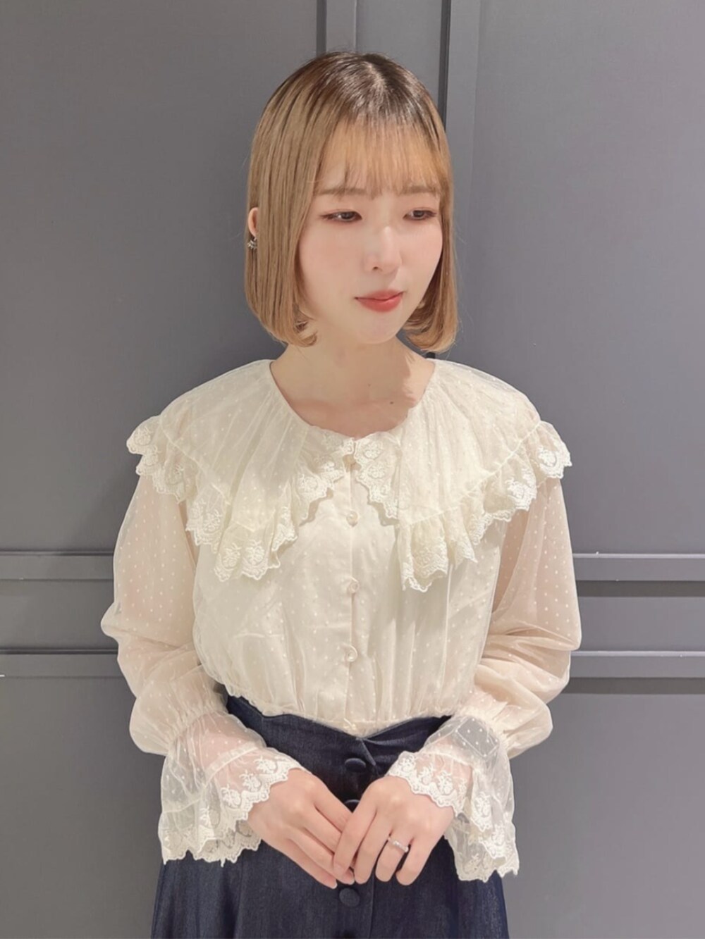 ブルー系のデニムスカート、ブラック系のパンプス、ブラック系のトートバッグを着用したレディースの秋コーディネートの3枚目の写真