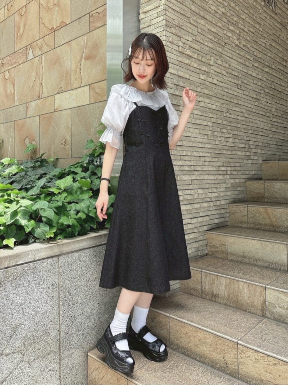 ブラック系のワンピース、ブラック系のサンダル、グレー系のシャツ/ブラウスを着用したレディースの夏コーディネートの2枚目の写真