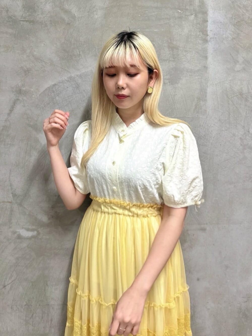 ブラウン系のパンプス、イエロー系のスカート、ホワイト系のシャツ/ブラウスを着用したレディースの夏コーディネートの3枚目の写真