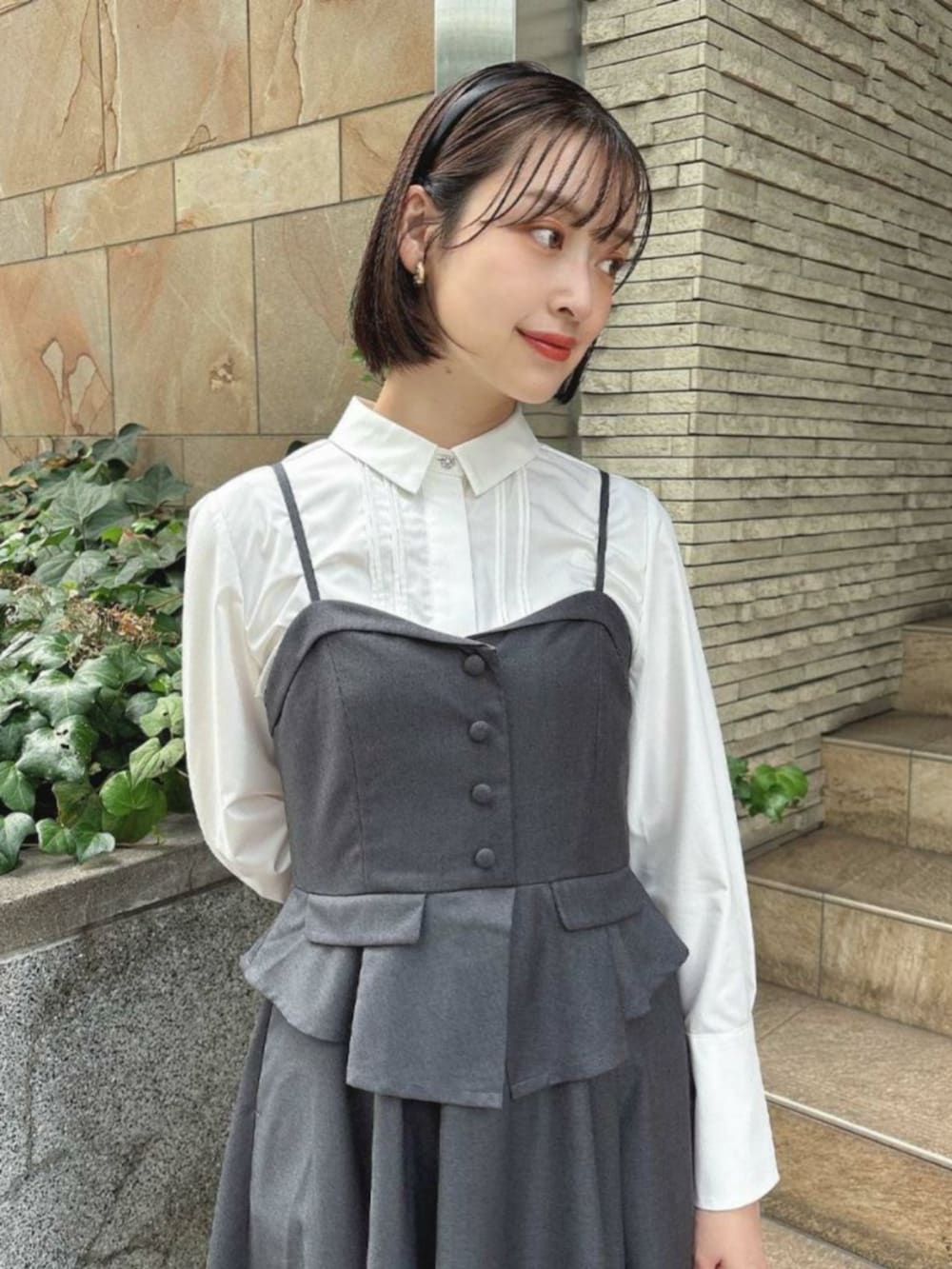 ブラック系のパンプス、グレー系のワンピース、ホワイト系のシャツ/ブラウスを着用したレディースの秋コーディネートの2枚目の写真