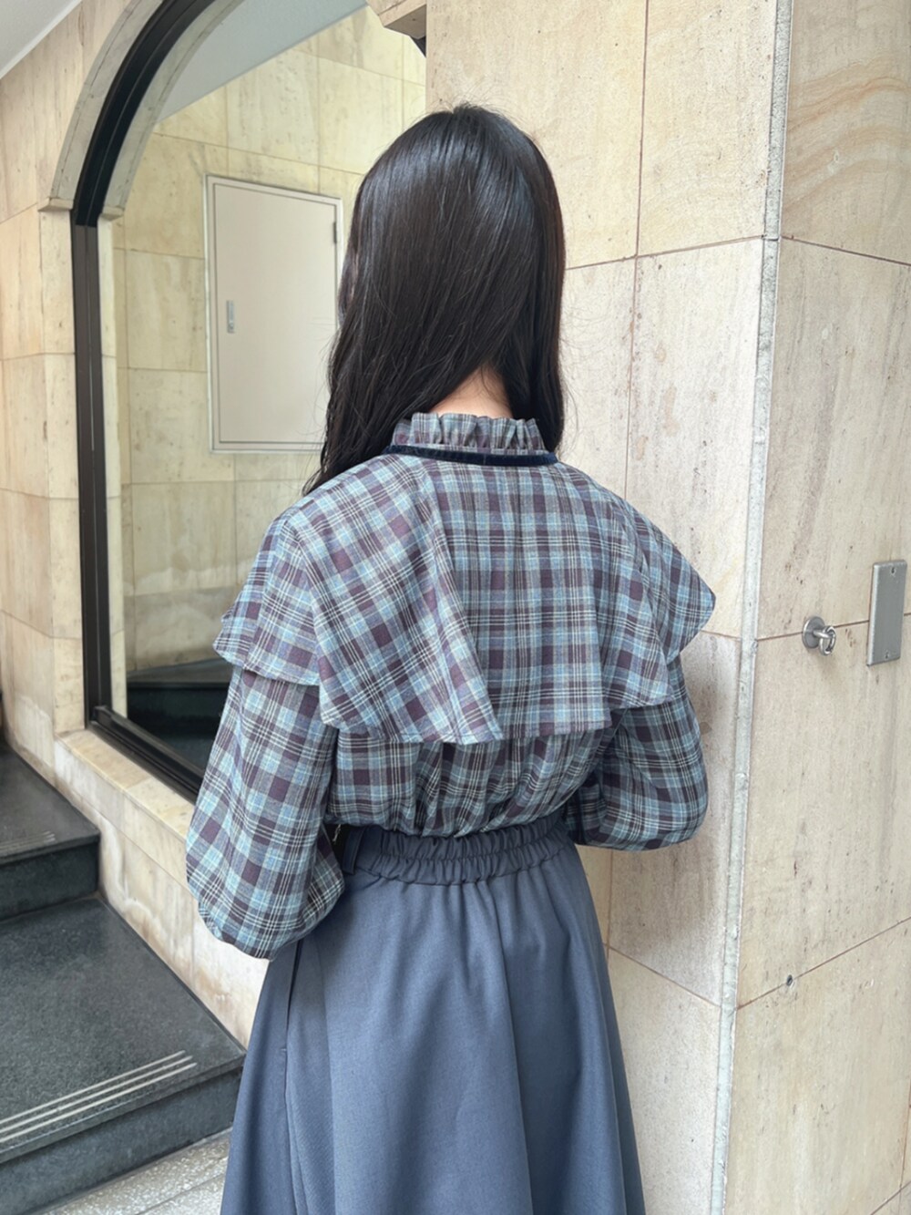 ブラック系のパンプス、ブルー系のシャツ/ブラウス、ブルー系のスカートを着用したレディースの秋コーディネートの4枚目の写真