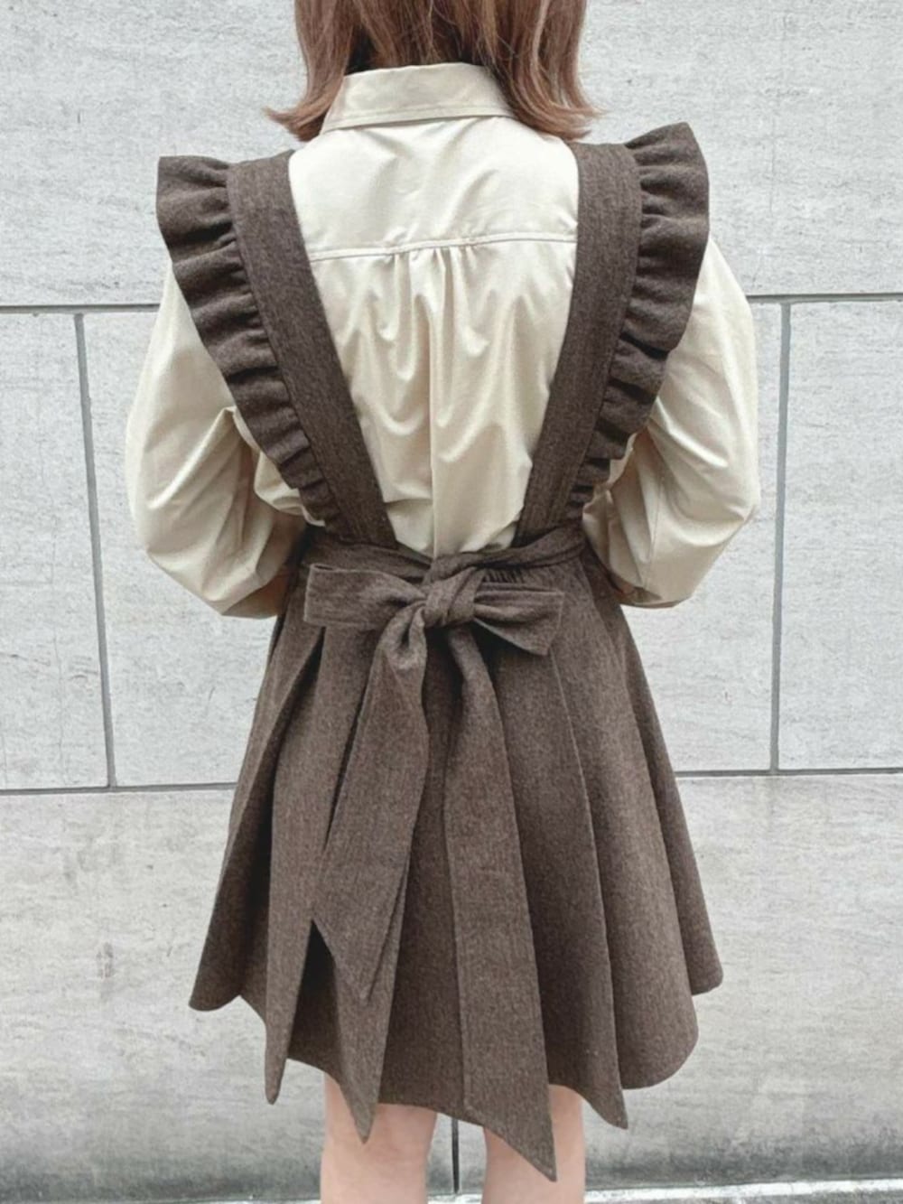 ブラック系のパンプス、ブラウン系のジャンパースカート、ベージュ系のシャツ/ブラウスを着用したレディースの秋コーディネートの3枚目の写真