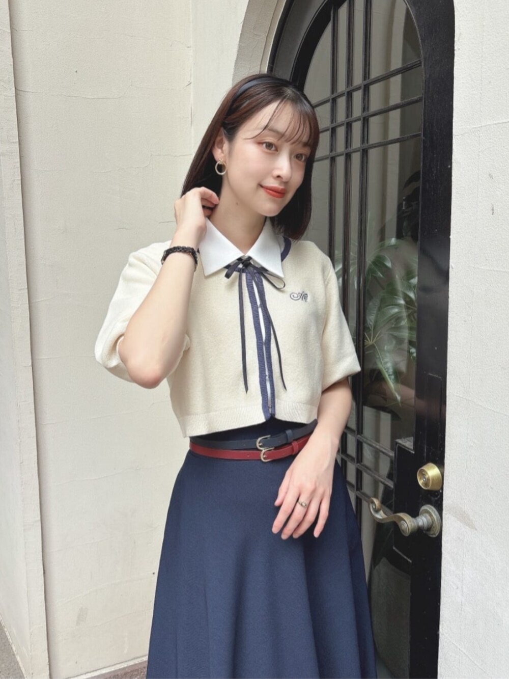 ホワイト系のカーディガン/ボレロ、ホワイト系のシャツ/ブラウス、ブルー系のスカートを着用したレディースの夏コーディネートの2枚目の写真