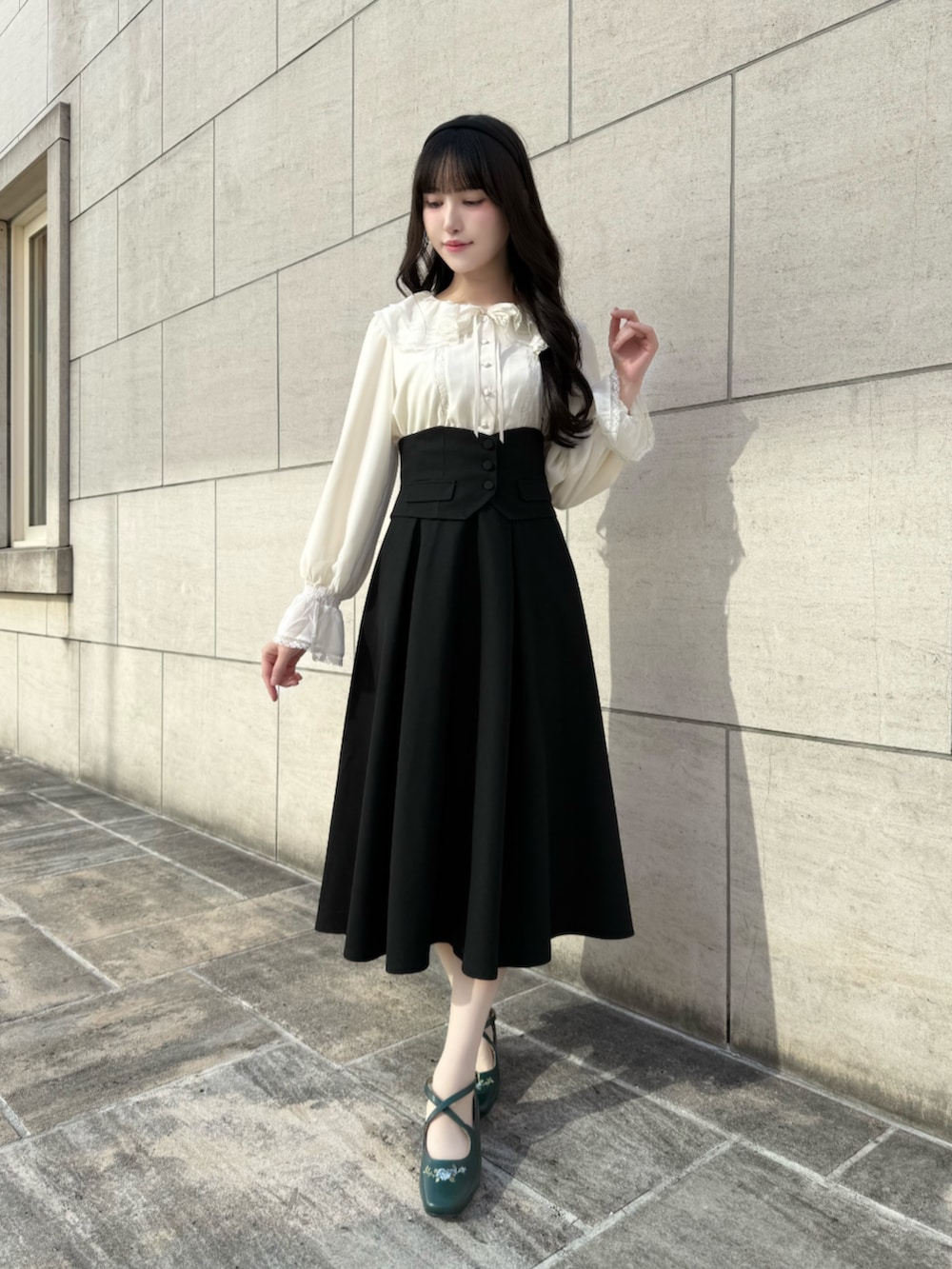 ブルー系のパンプス、ブラック系のスカートを着用したレディースの秋コーディネートの2枚目の写真