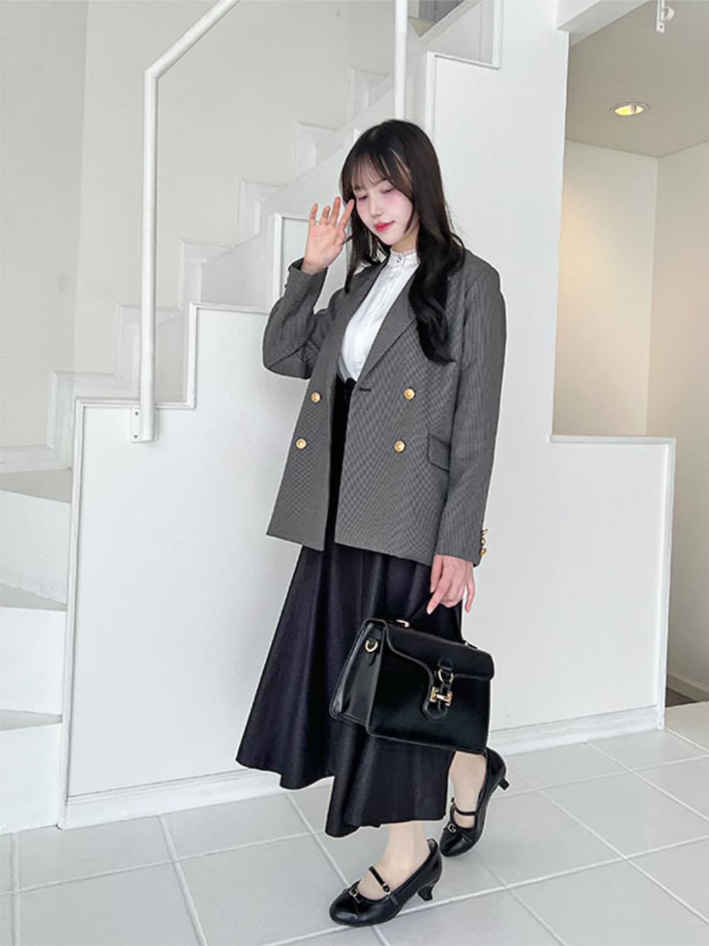 ブラック系のハンドバッグ、ブラック系のデニムスカート、ホワイト系のシャツ/ブラウスを着用したレディースの秋コーディネートの2枚目の写真