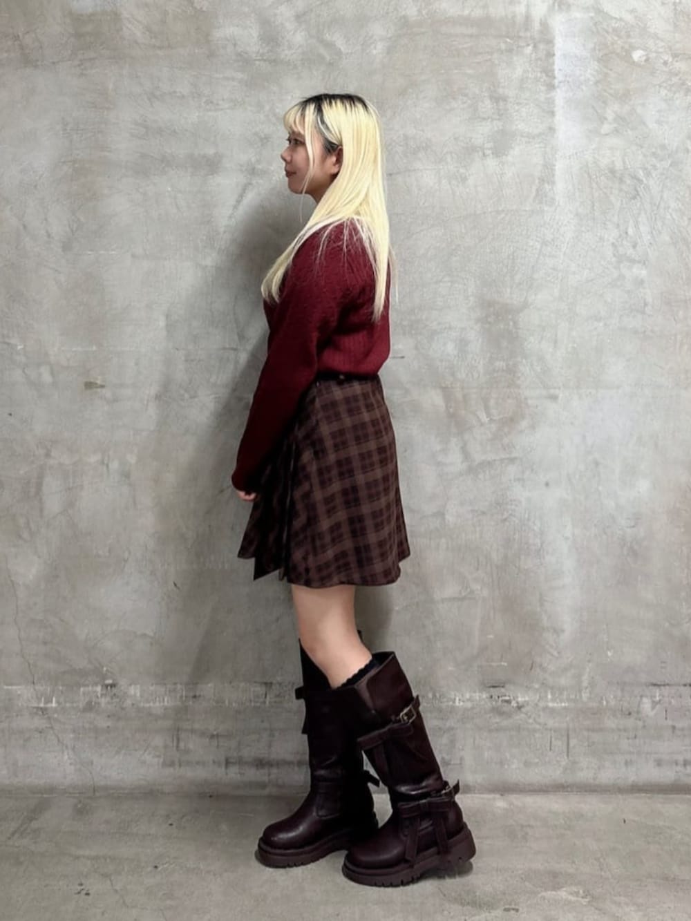 ブラウン系のスカート、ブラウン系のブーツ、レッド系のニット/セーターを着用したレディースの冬コーディネートの2枚目の写真