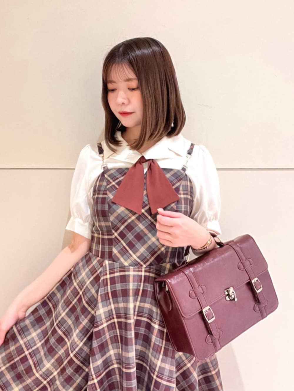 ブラウン系のパンプス、ブラウン系のショルダーバッグ、ホワイト系のシャツ/ブラウスを着用したレディースの夏コーディネートの3枚目の写真