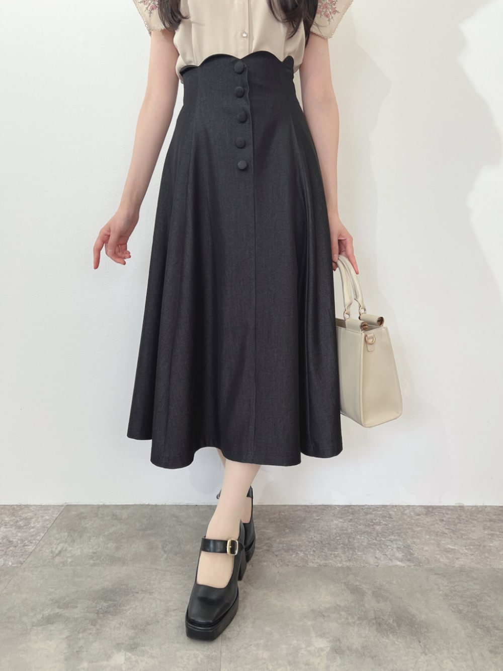 ブラック系のパンプス、ピンク系のシャツ/ブラウス、ブラック系のデニムスカートを着用したレディースの夏コーディネートの3枚目の写真