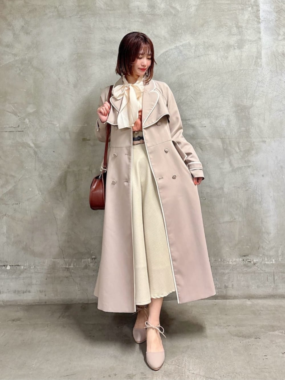 ブラウン系のショルダーバッグ、ピンク系のシャツ/ブラウス、ベージュ系のスカートを着用したレディースの春コーディネートの2枚目の写真