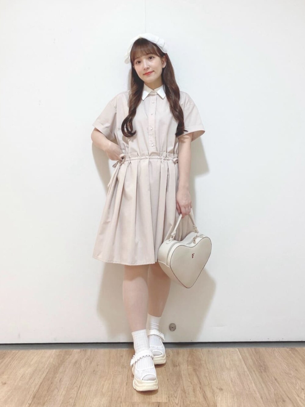 ホワイト系のハンドバッグ、ホワイト系のサンダル、ピンク系のシャツワンピースを着用したレディースの夏コーディネートの3枚目の写真