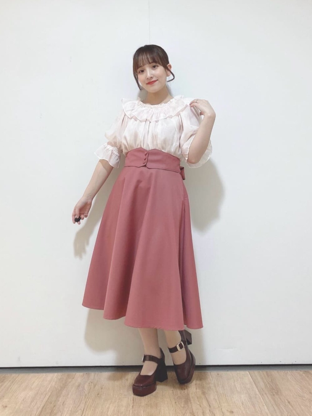ピンク系のスカート、ブラウン系のパンプス、ピンク系のシャツ/ブラウスを着用したレディースの夏コーディネートの2枚目の写真